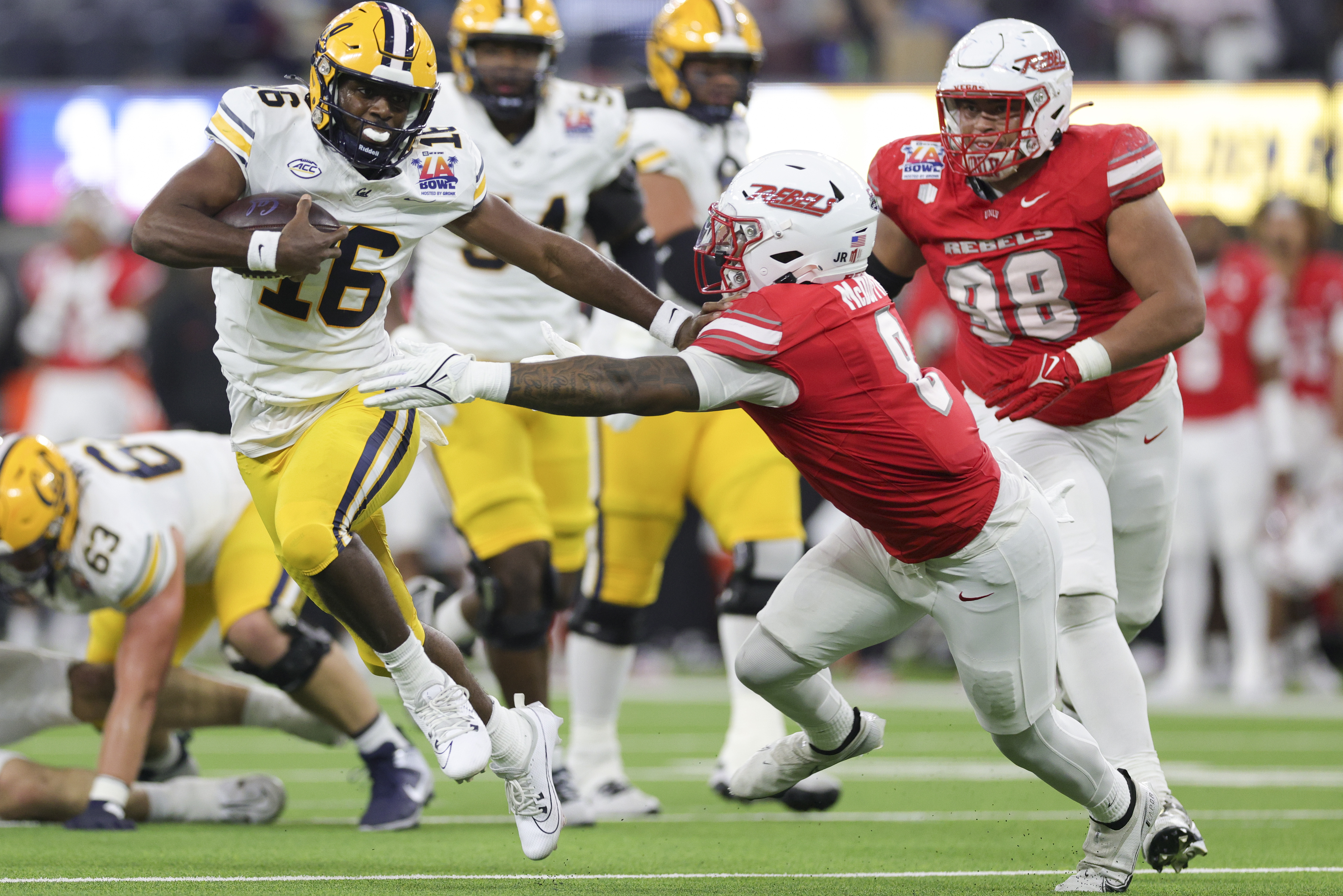 California quarterback CJ Harris, left, stiff arms UNLV linebacker Marsel McDuffie during the first half of the LA Bowl NCAA college football game Wednesday, Dec. 18, 2024, in Inglewood, Calif.