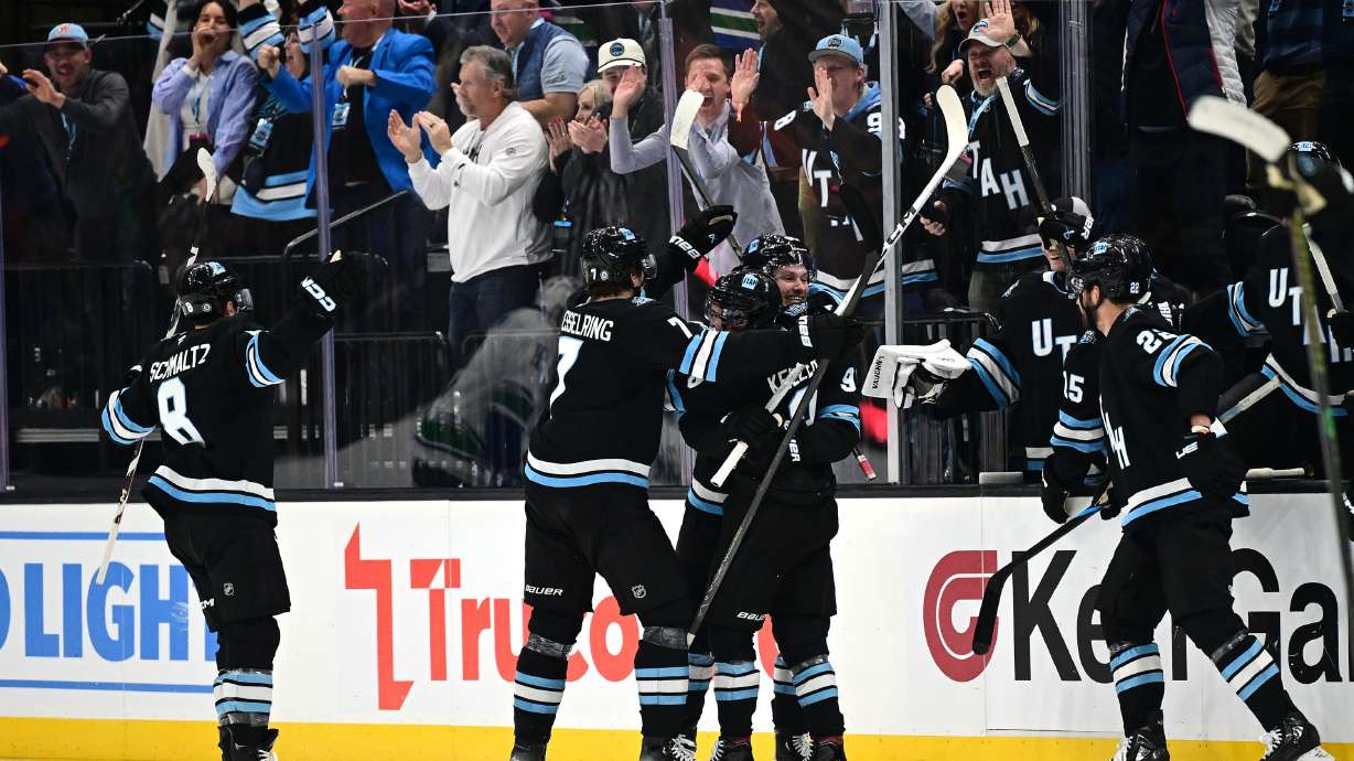 Utah Hockey Club defenseman Mikhail Sergachev (98) and teammates celebrates with teammates after scoring the game winning goal as the Utah Hockey Club and Vancouver Canucks play at the Delta Center in Salt Lake City on Wednesday Dec. 18, 2024. Utah won 3-2 in overtime.