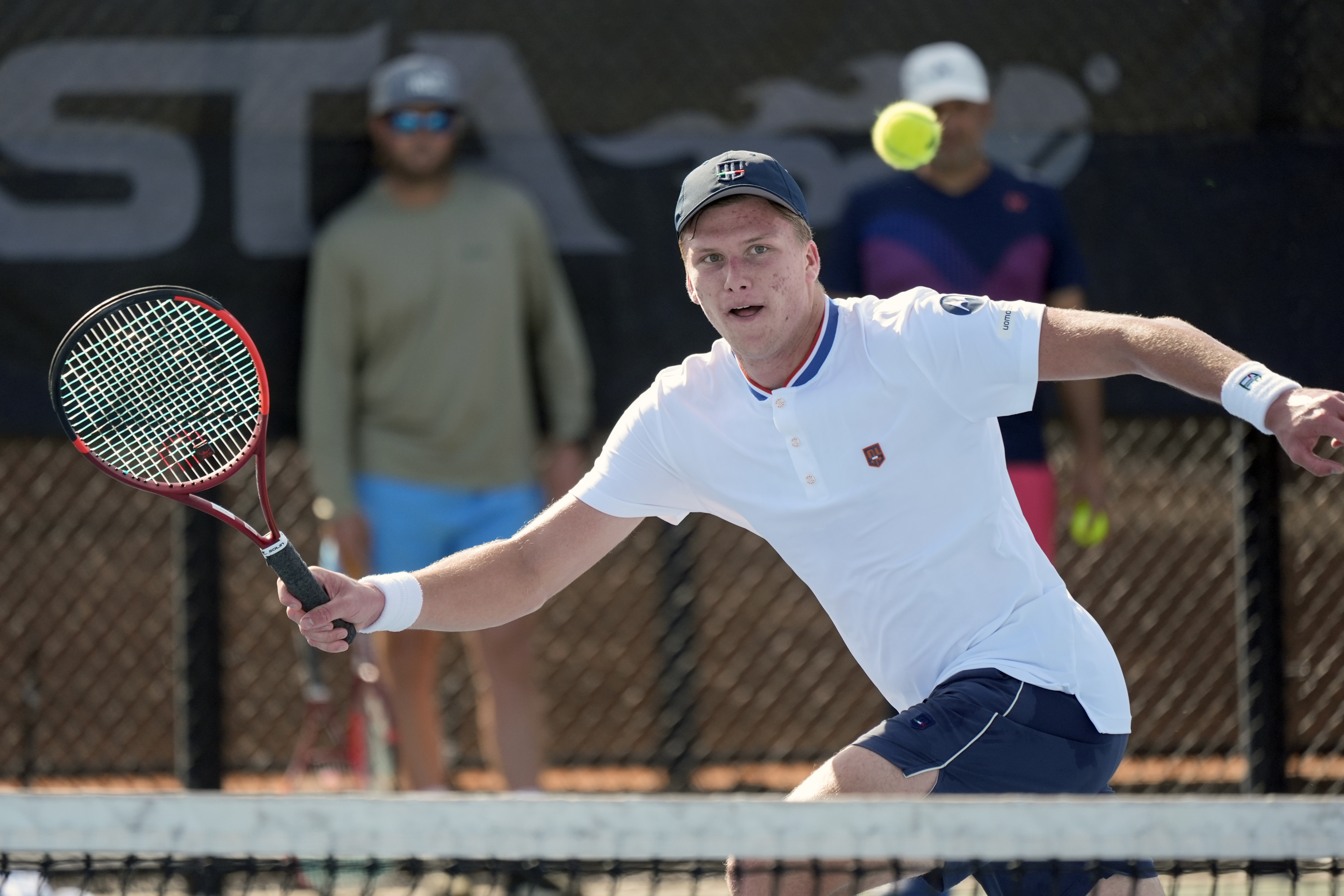 Tennis player Jenson Brooksby practices at the USTA national campus while his coaches Rhyne Williams, back left, and Eric Nunez watch, Tuesday, Dec. 10, 2024, in Orlando, Fla.