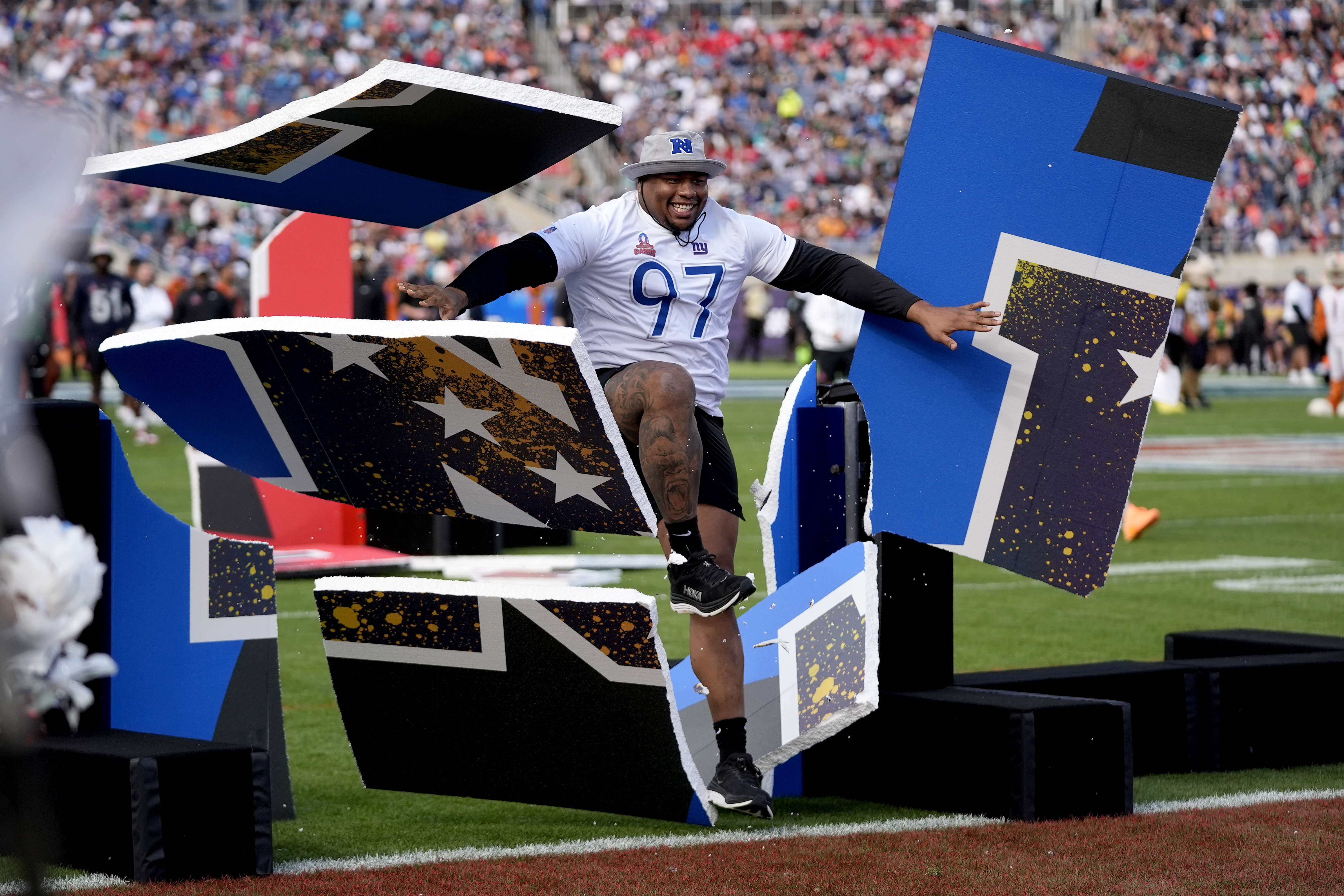 FILE - NFC Dexter Lawrence, of the New York Giants, breaks through a barrier during the skills event at the NFL Pro Bowl football game, Feb. 4, 2024, in Orlando.