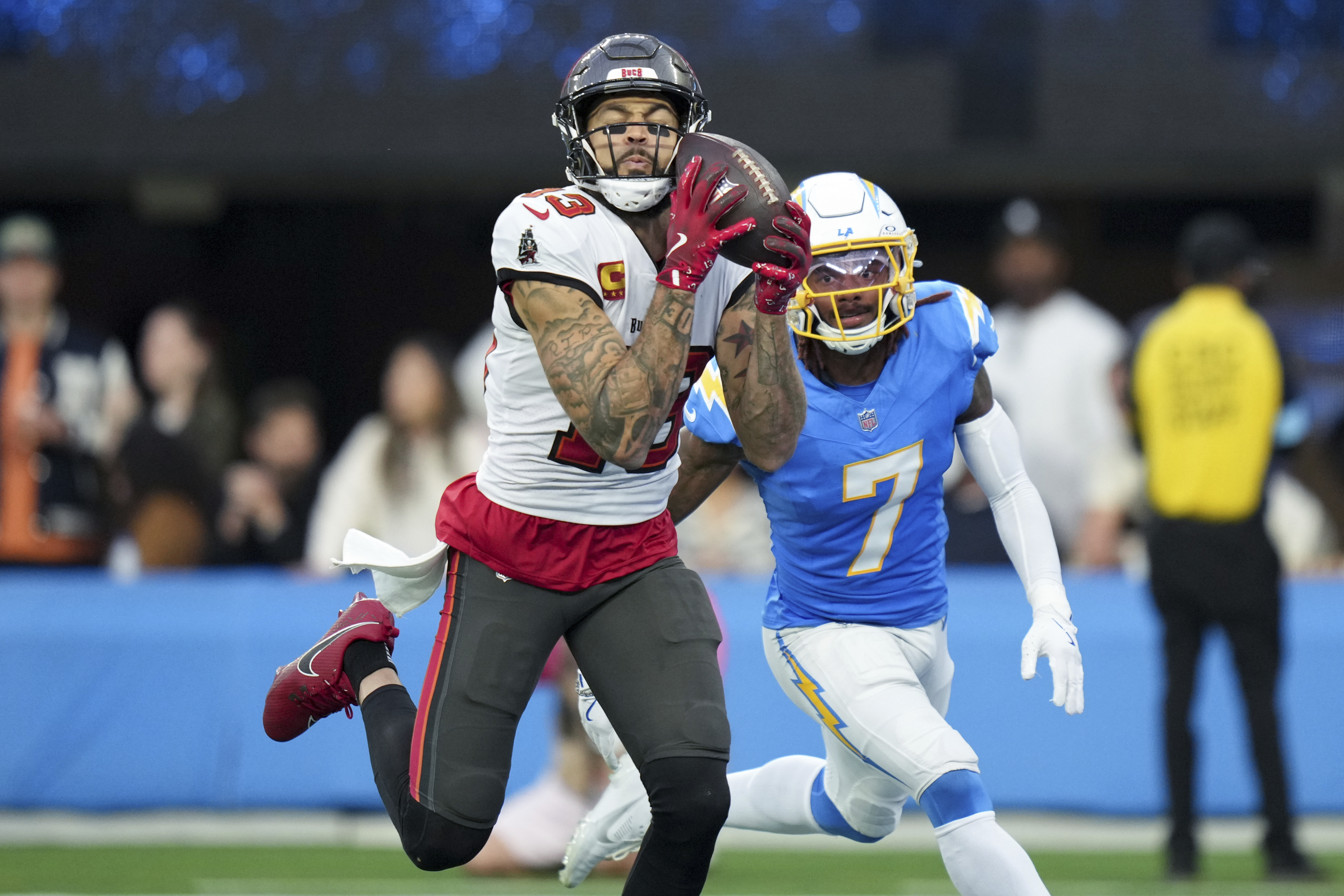 Tampa Bay Buccaneers wide receiver Mike Evans, left, catches a touchdown past Los Angeles Chargers cornerback Kristian Fulton (7) during the first half of an NFL football game Sunday, Dec. 15, 2024, in Inglewood, Calif. .
