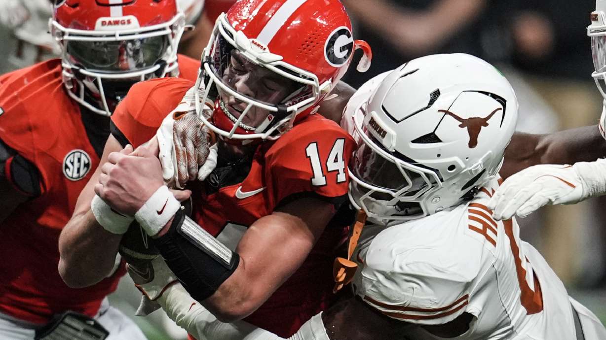Texas linebacker Anthony Hill Jr. (0) hits Georgia quarterback Gunner Stockton (14) during the second half of the Southeastern Conference championship NCAA college football game, Saturday, Dec. 7, 2024, in Atlanta.