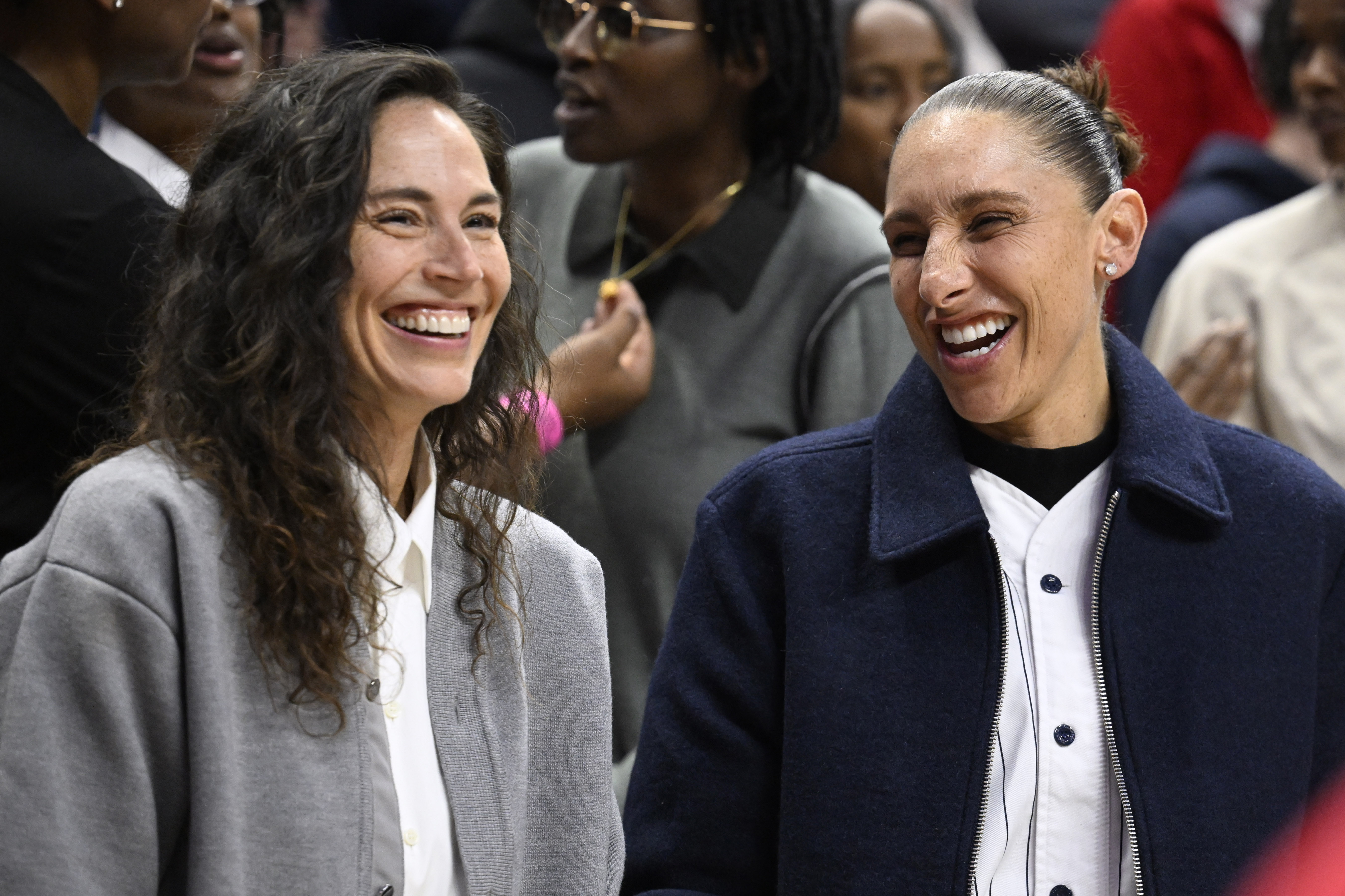 Former UConn players Sue Bird, left, and Diana Taurasi, share a laugh during a pregame ceremony honoring Geno Auriemma and longtime assistant Chris Dailey, Wednesday, Nov. 20, 2024, in Storrs, Conn. 