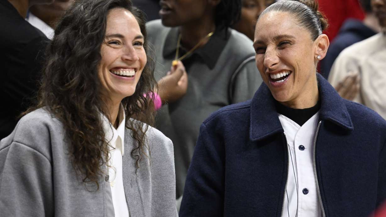 Former UConn players Sue Bird, left, and Diana Taurasi, share a laugh during a pregame ceremony honoring Geno Auriemma and longtime assistant Chris Dailey, Wednesday, Nov. 20, 2024, in Storrs, Conn.