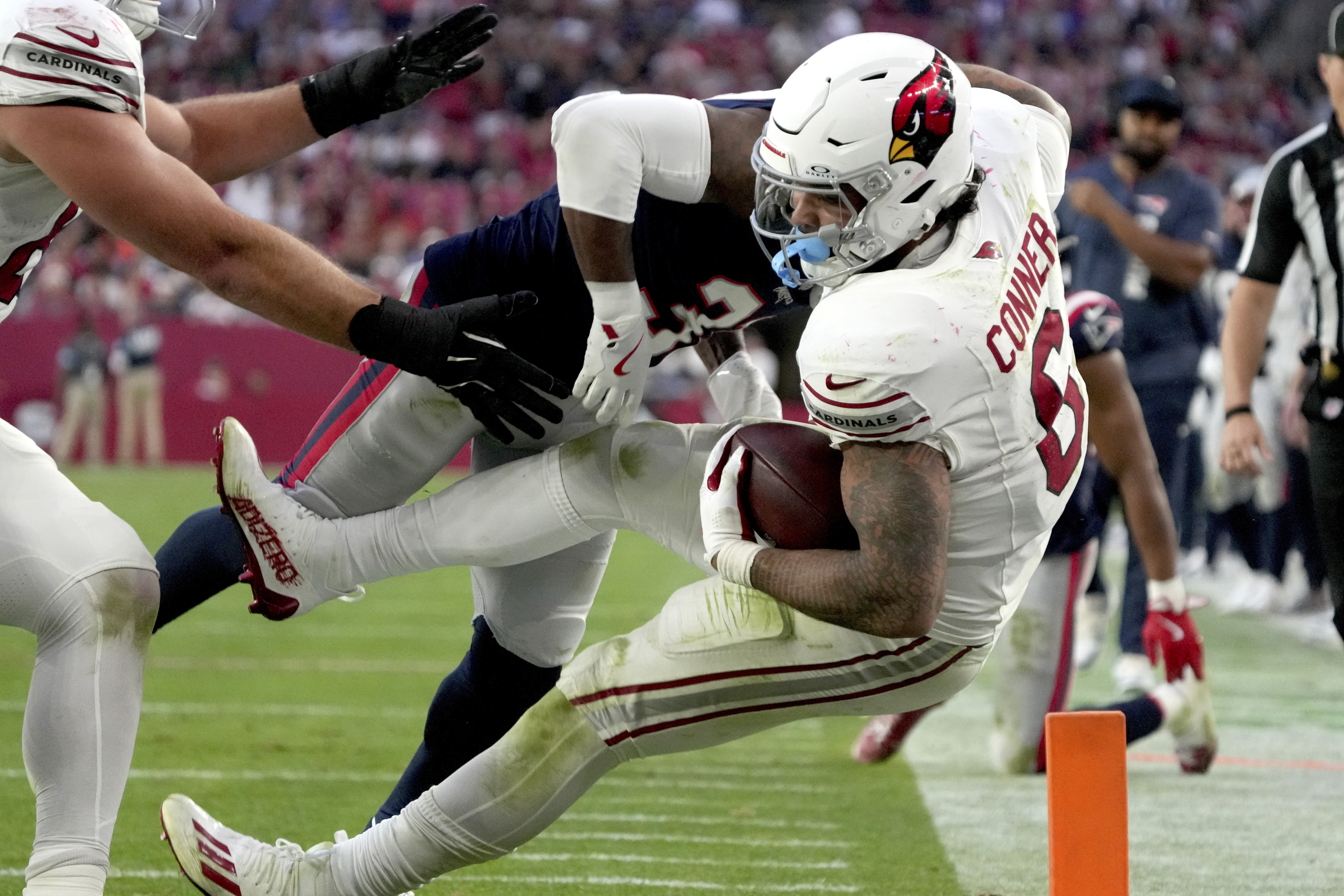 New England Patriots cornerback Jonathan Jones tackles Arizona Cardinals running back James Conner (6) during the second half of an NFL football game, Sunday, Dec. 15, 2024, in Glendale, Ariz. 