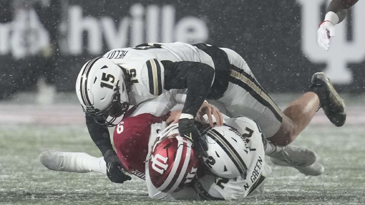 Indiana quarterback Kurtis Rourke (9) is sacked by Purdue defensive back Nyland Green (2) and defensive end Will Heldt (15) during the first half of an NCAA college football game, Saturday, Nov. 30, 2024, in Bloomington, Ind.