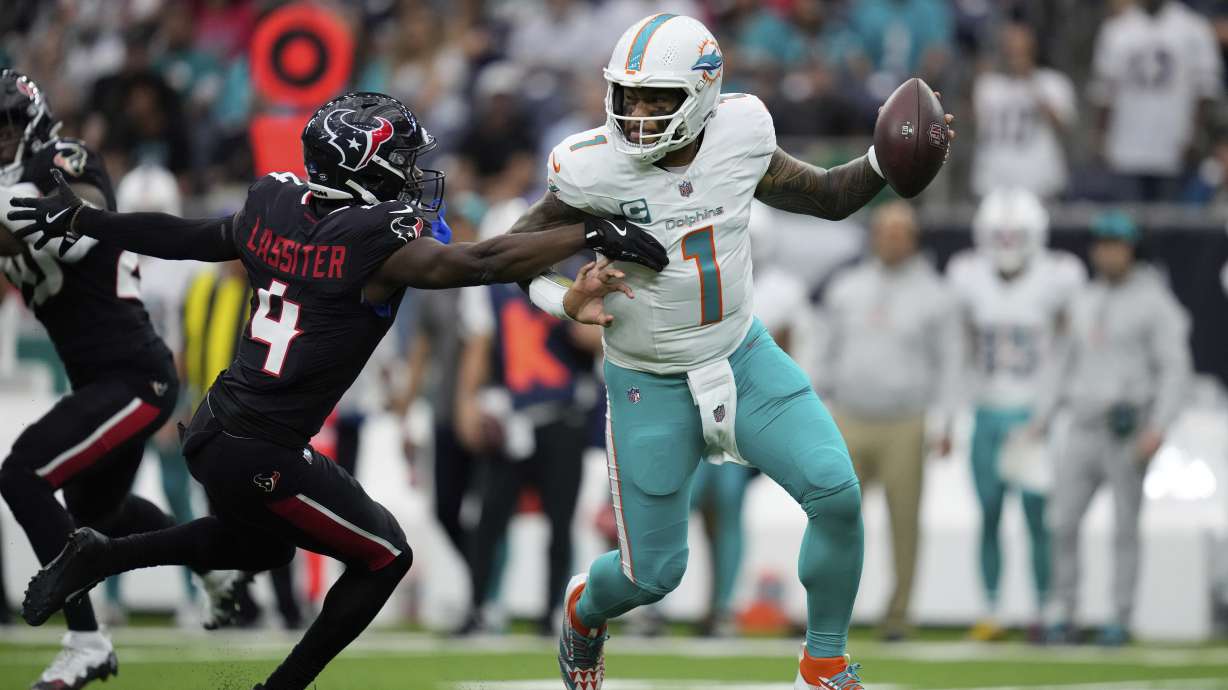Miami Dolphins quarterback Tua Tagovailoa (1) comes under pressure from Houston Texans cornerback Kamari Lassiter (4) during the first half of an NFL football game Sunday, Dec. 15, 2024, in Houston.