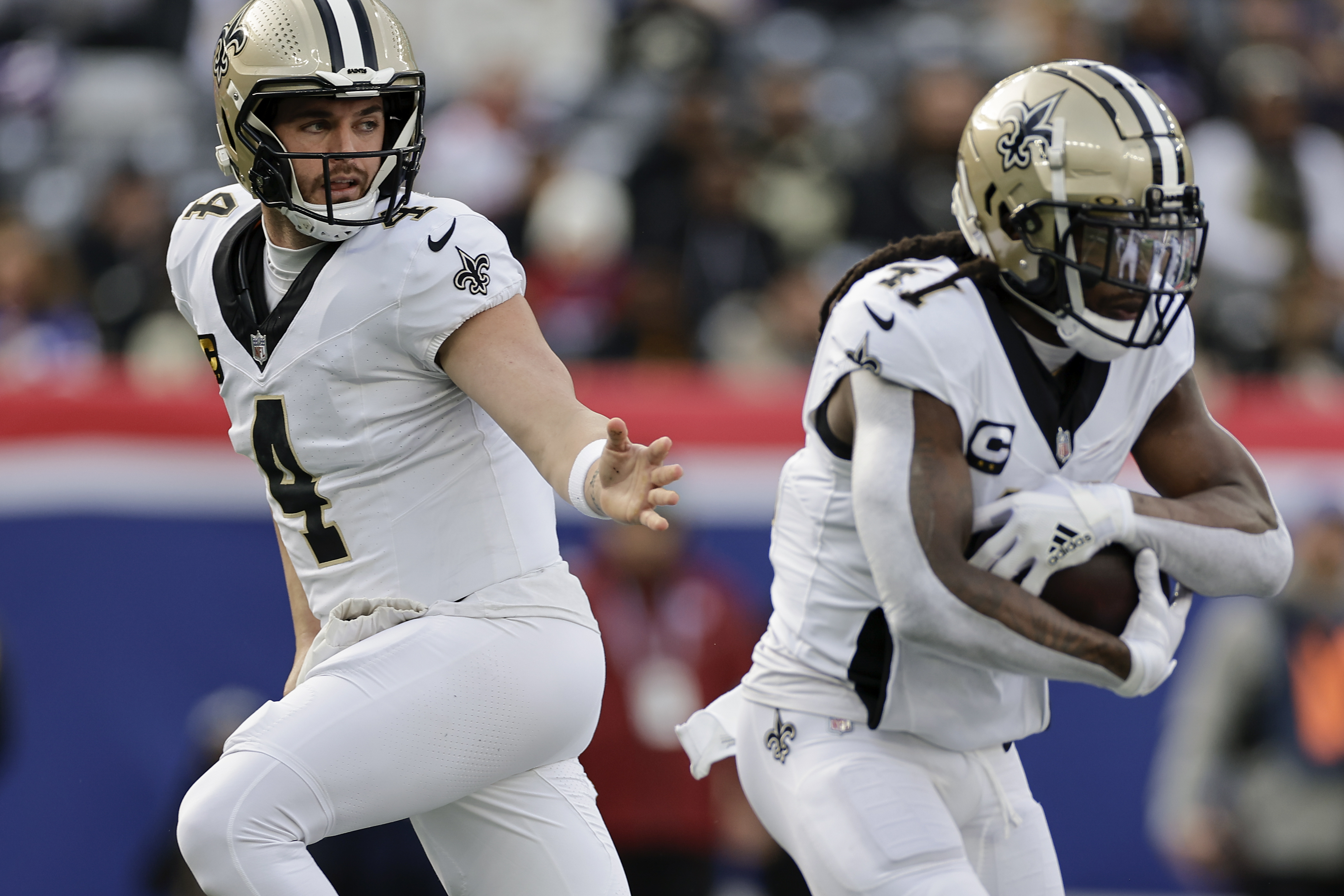 New Orleans Saints quarterback Derek Carr (4) hands off the ball to running back Alvin Kamara (41) during the first quarter of an NFL football game against the New York Giants, Sunday, Dec. 8, 2024, in East Rutherford, N.J. 