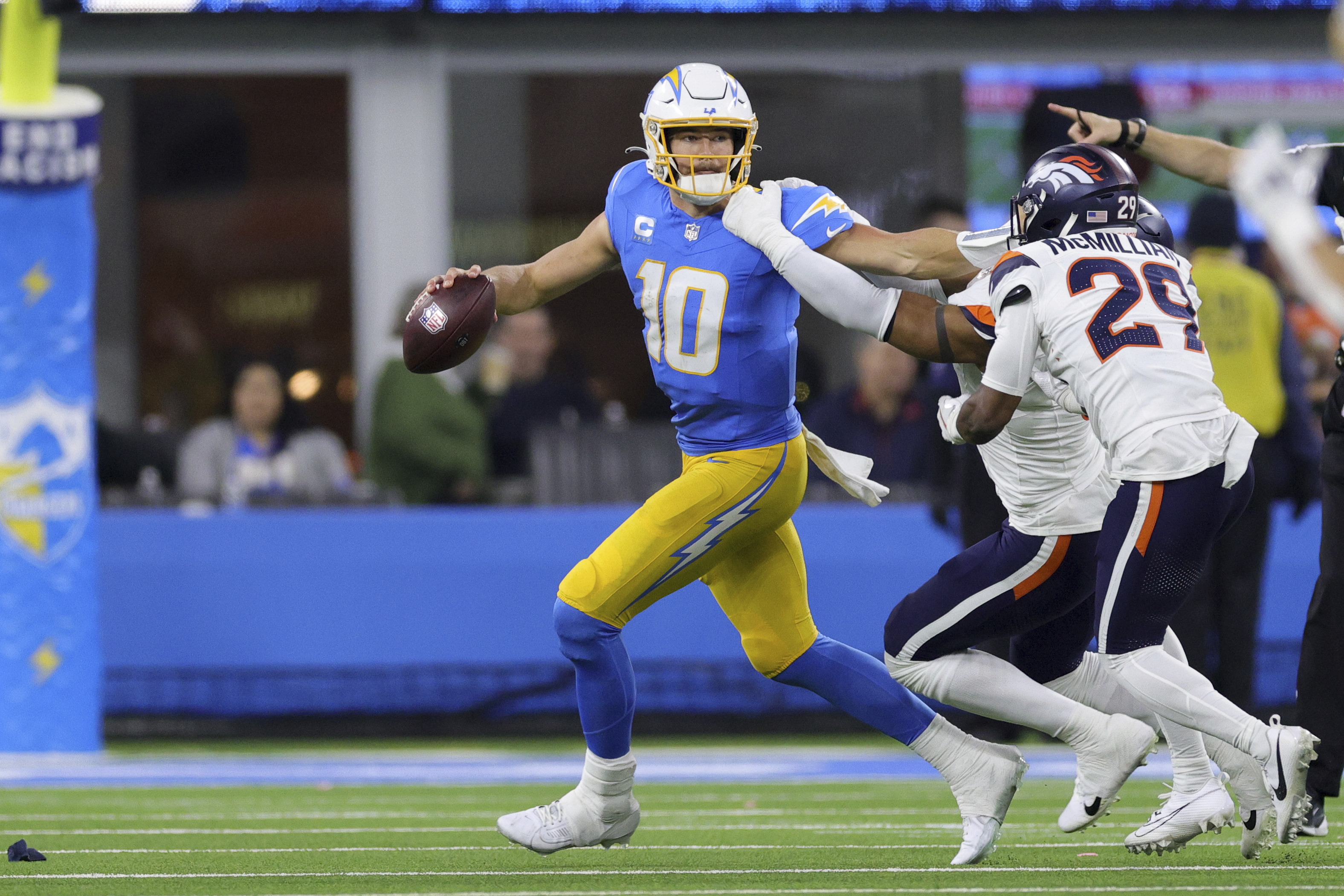 Los Angeles Chargers quarterback Justin Herbert (10) his pressured as he rolls out of the pocket during the second half an NFL football game against the Denver Broncos, Thursday, Dec. 19, 2024, in Inglewood, Calif.