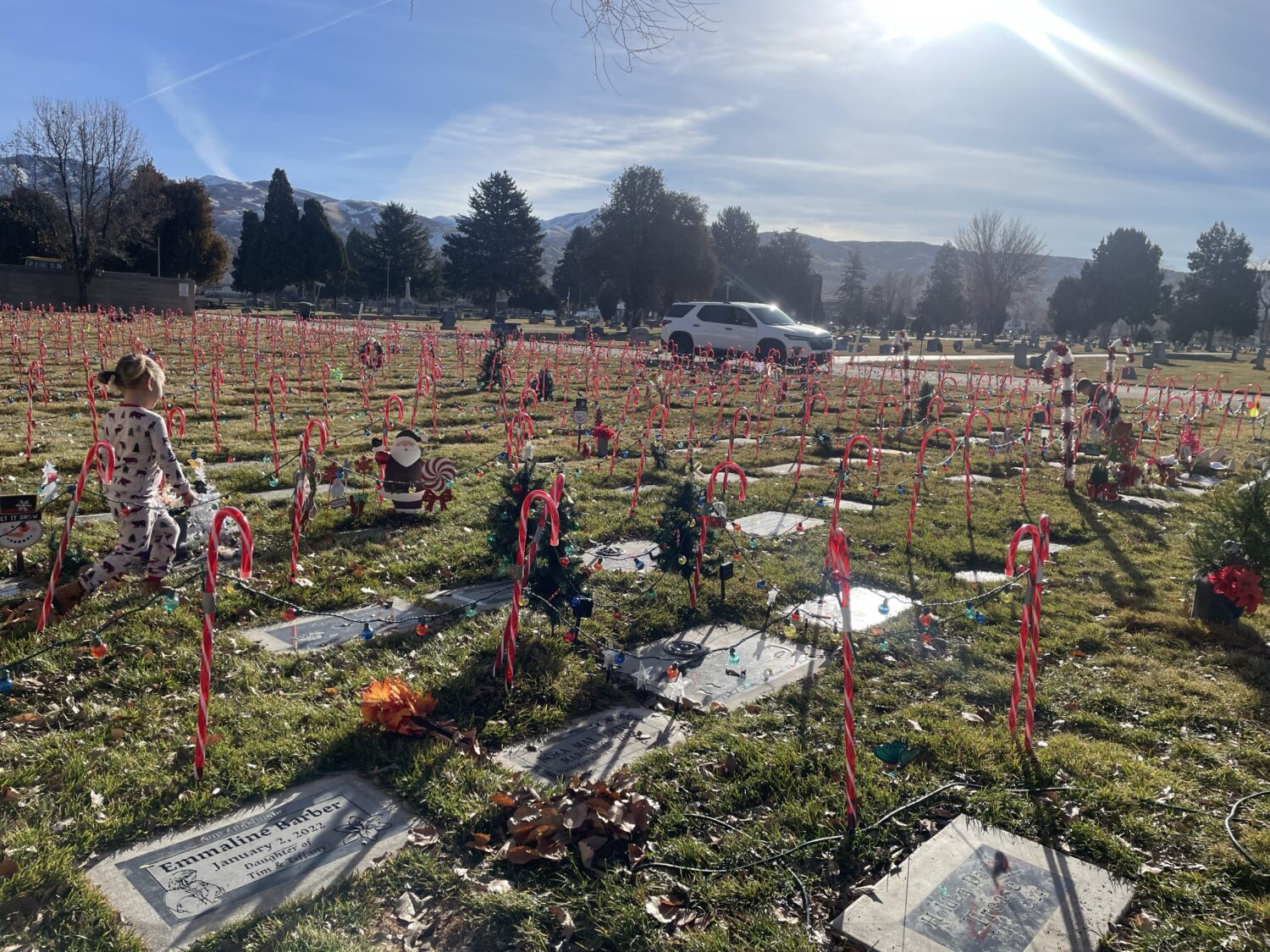 Candy cane decorations are shown on children's graves in the Davis County cemetery on Thursday. A Utah woman and her family decorate the graves each year.