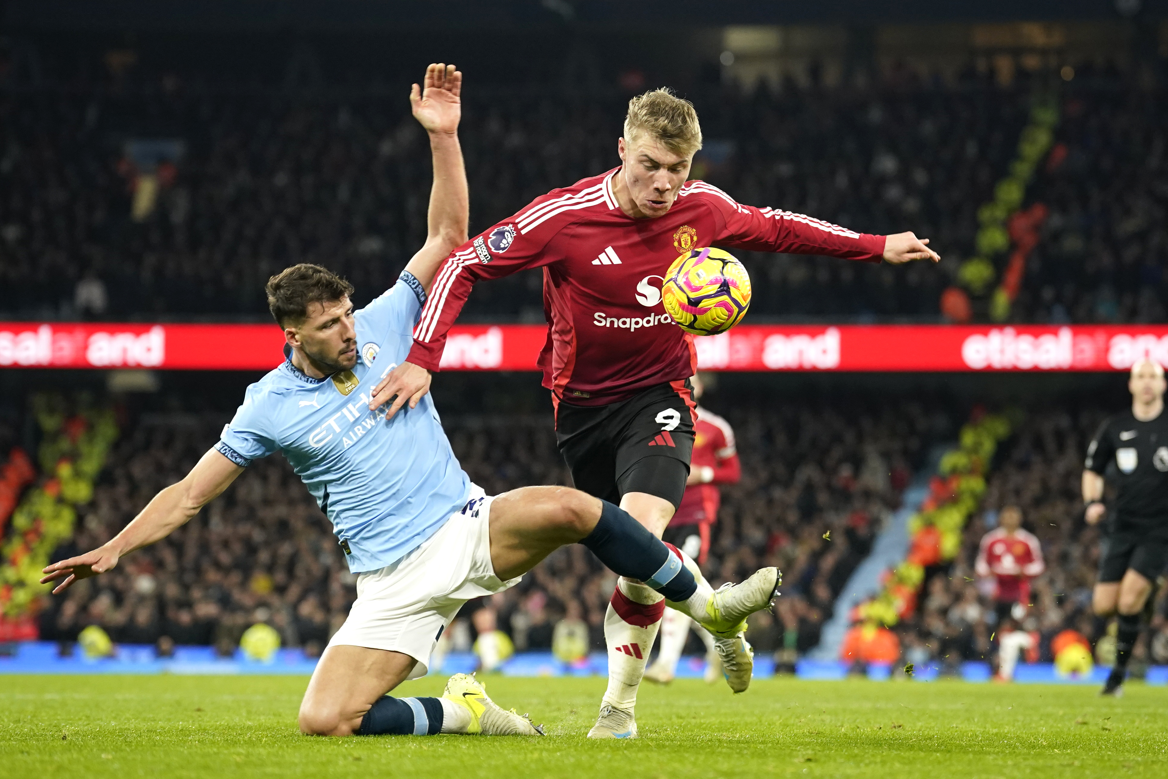 Manchester City's Ruben Dias, left, challenges for the ball with Manchester United's Rasmus Hojlund during the English Premier League soccer match between Manchester City and Manchester United at the Etihad Stadium in Manchester, Sunday, Dec. 15, 2024.
