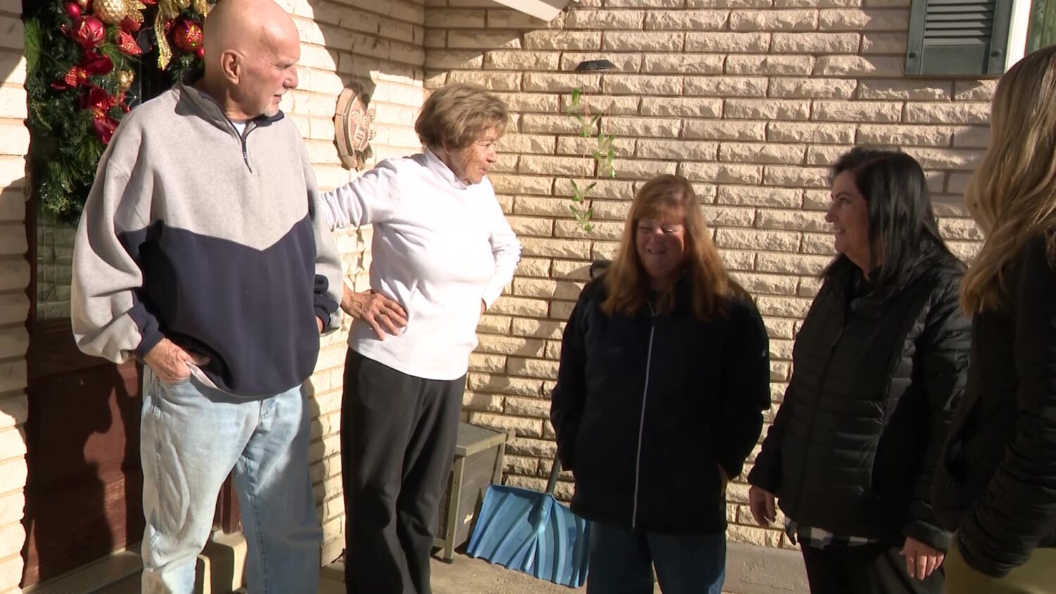 Marianne Peterson, second from left, outside her home with Cathy and Carol Stoker, who came to deliver Peterson fresh water.