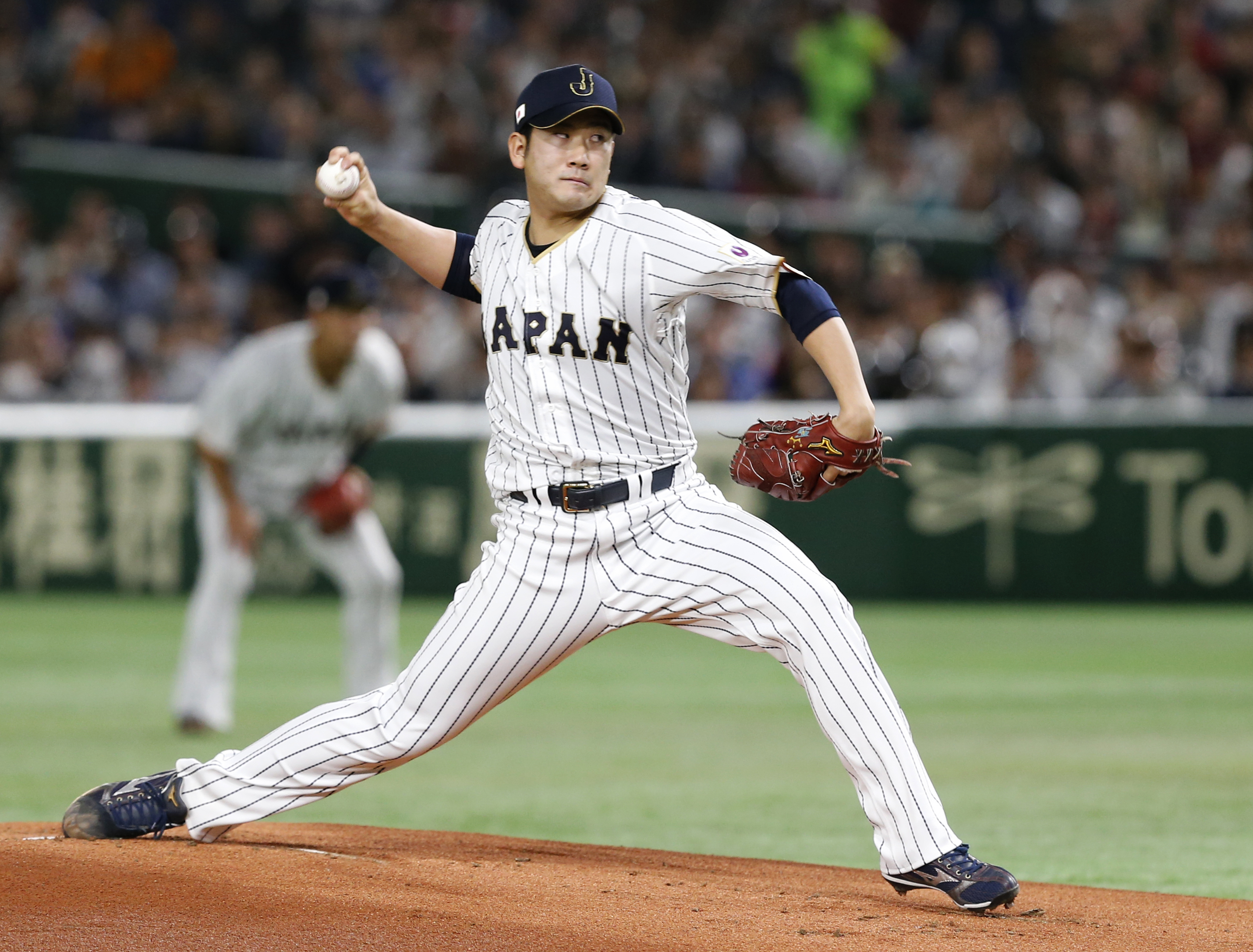 FILE - Japan's starter Tomoyuki Sugano pitches against Cuba during the first inning of their second round game at the World Baseball Classic at Tokyo Dome in Tokyo, on March 14, 2017.