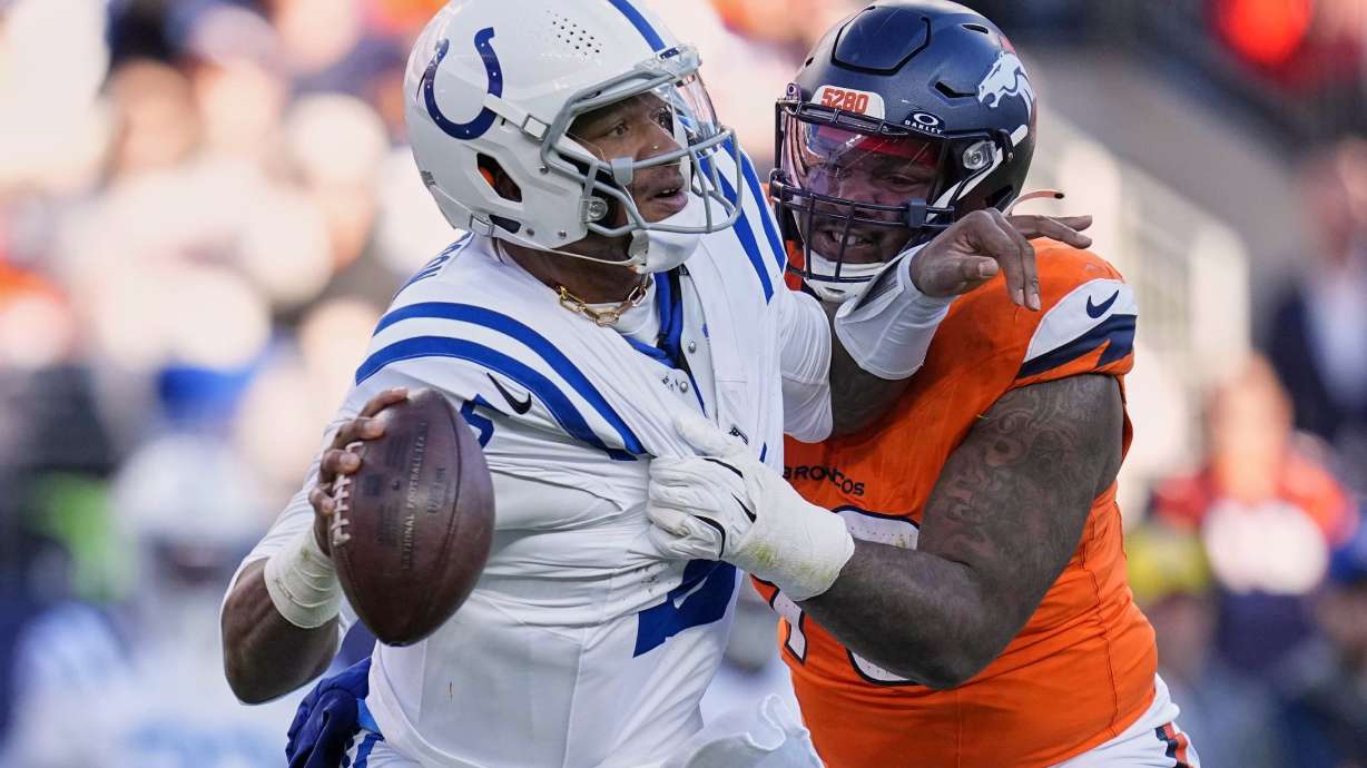 Indianapolis Colts' Anthony Richardson gets away from Denver Broncos' John Franklin-Myers during the first half of an NFL football game Sunday, Dec. 15, 2024, in Denver.