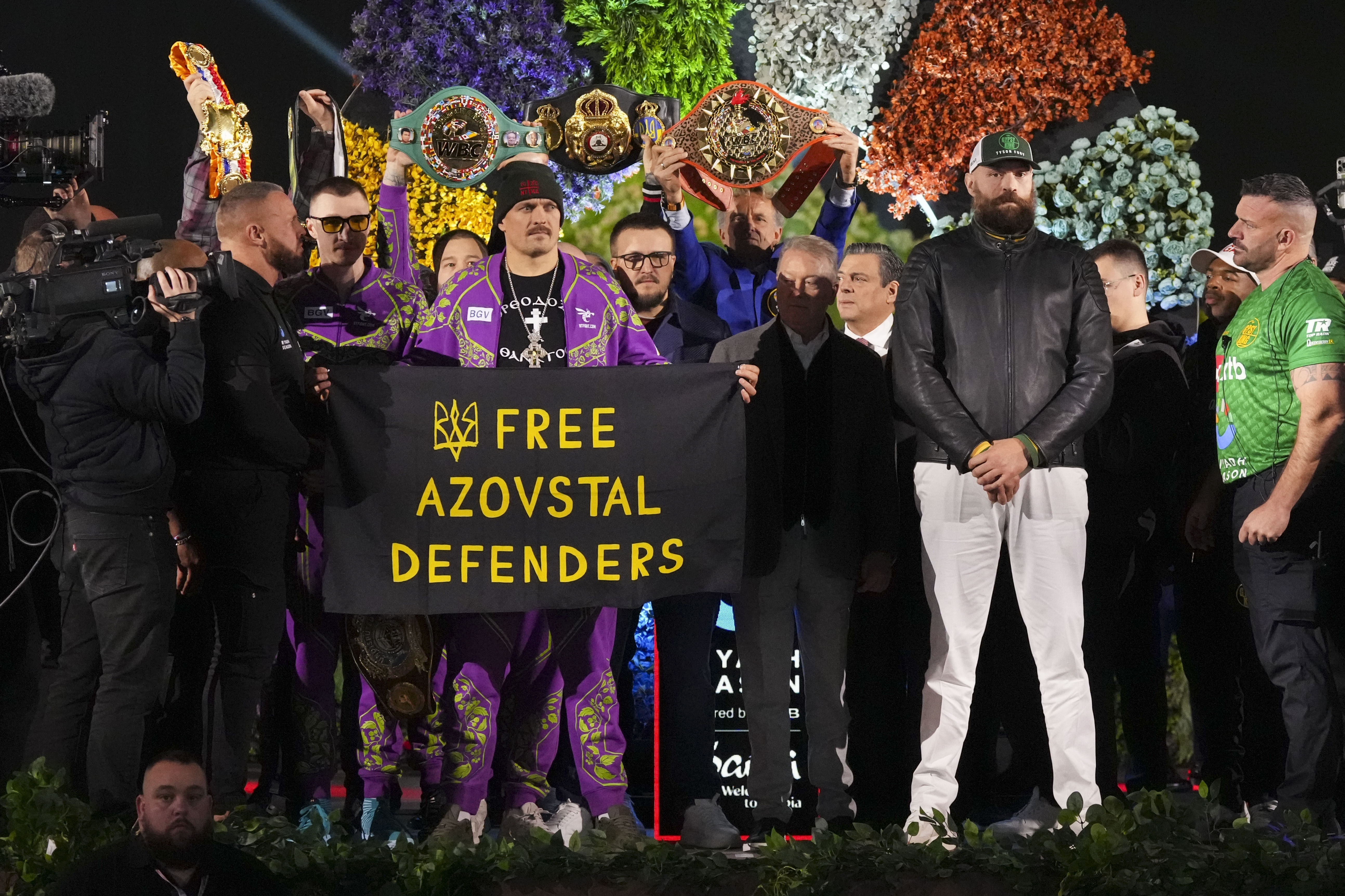 Boxers Britain's Tyson Fury, third right, and world champion Ukraine's Oleksandr Usyk, center left, stand on stage during the weigh-in for their WBA, WBO, and WBC heavyweight title bout in Riyadh, Saudi Arabia, Friday, Dec. 20, 2024. 