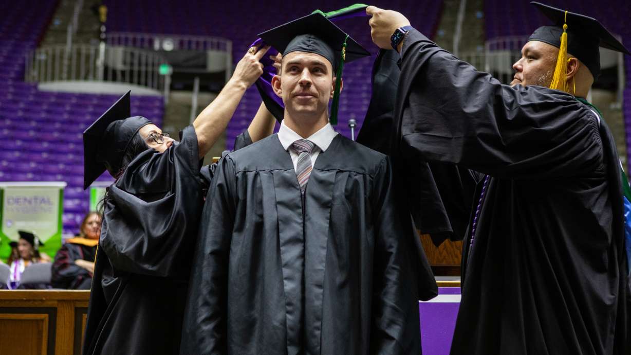 Weber State physician assistant master's degree graduate Collin Stoker, center, is honored by faculty members during the Ogden school's graduation exercises on Dec. 13.
