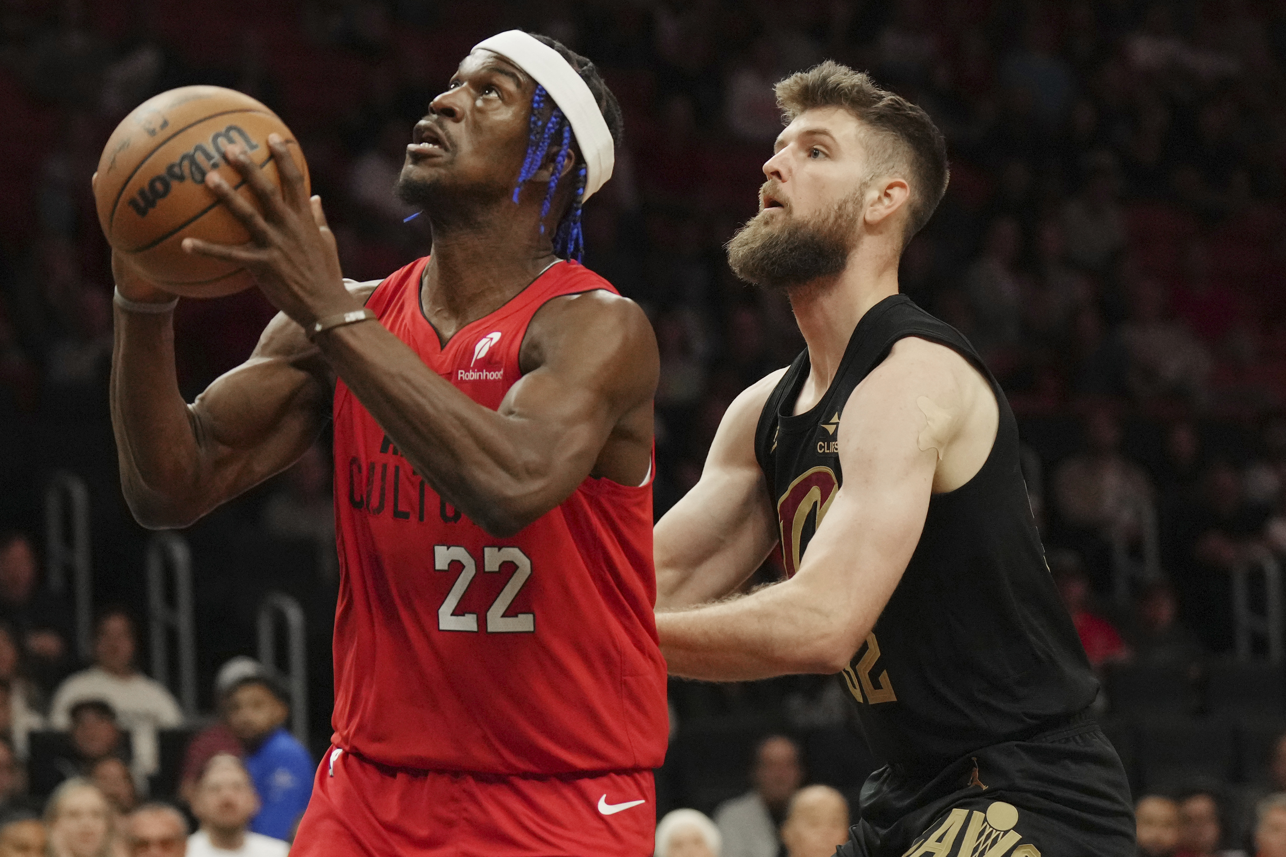 Miami Heat forward Jimmy Butler (22) goes up to shoot as Cleveland Cavaliers forward Dean Wade, right, defends during the first half of an NBA basketball game, Sunday, Dec. 8, 2024, in Miami.