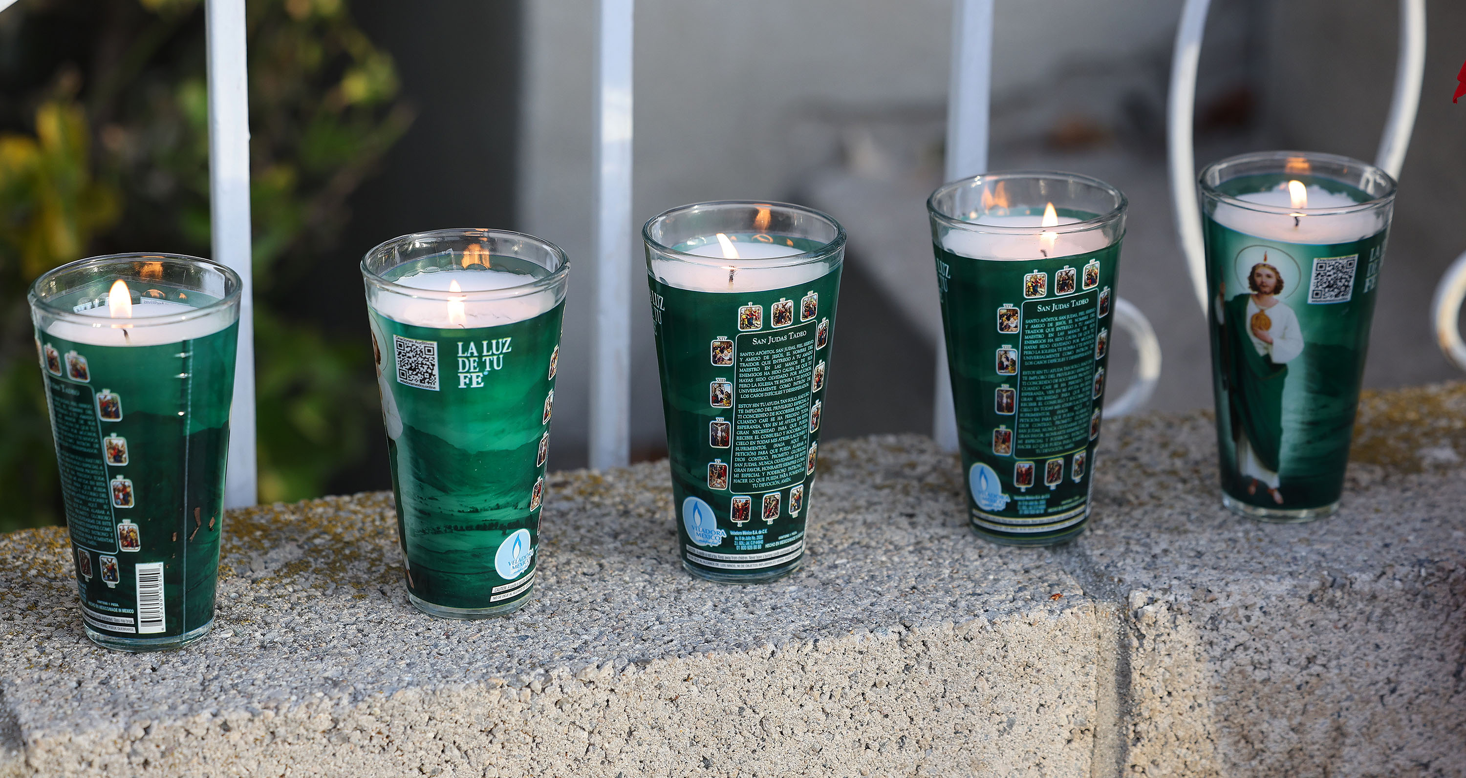 Lit candles left by mourners sit outside a West Valley City home on Wednesday after an apparent murder-suicide in the residence that left five dead. West Valley police suspect the father shot his family members then himself.