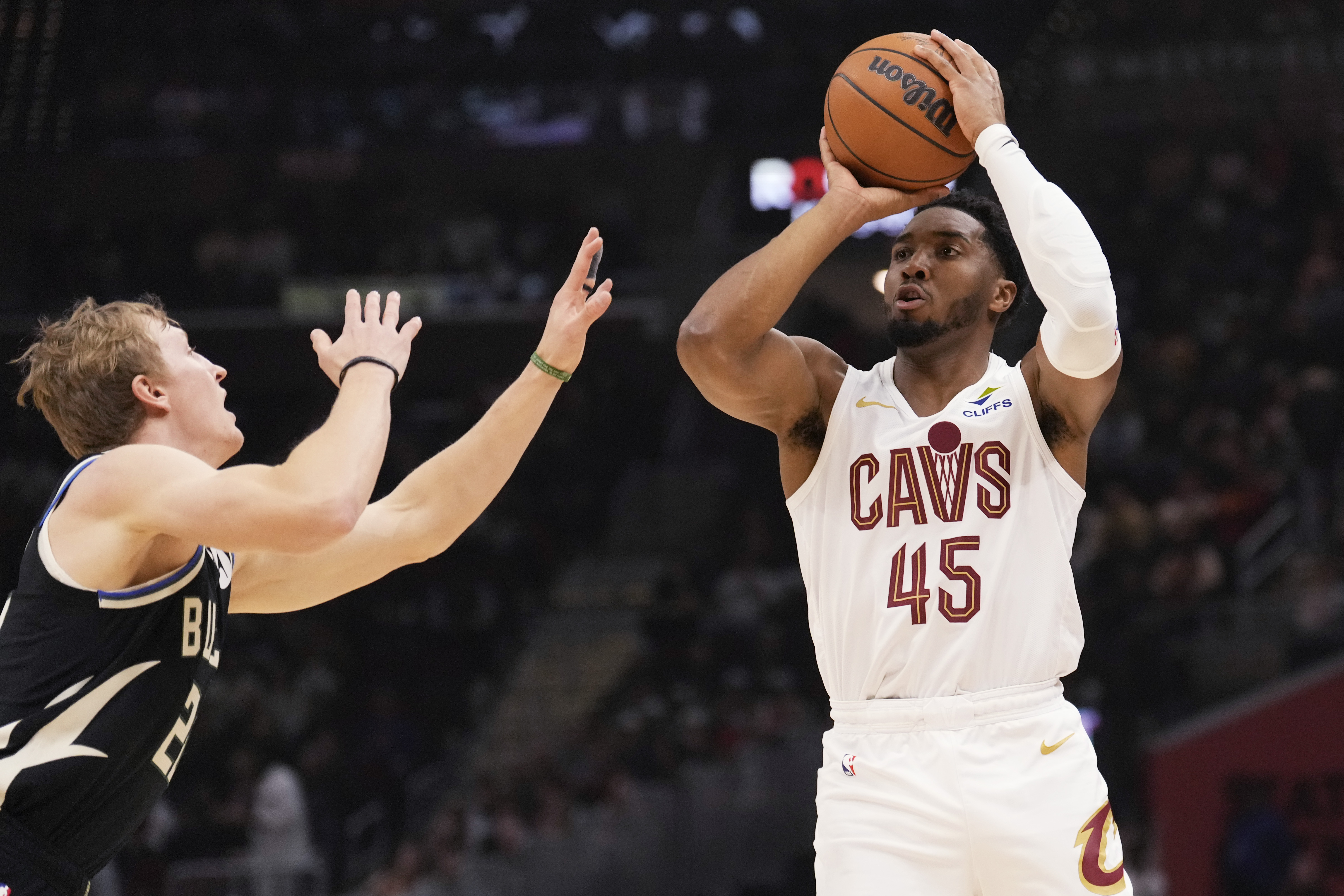 Cleveland Cavaliers guard Donovan Mitchell (45) shoots over Milwaukee Bucks guard AJ Green, left, in the first half of an NBA basketball game, Friday, Dec. 20, 2024, in Cleveland.