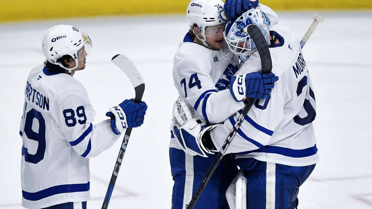 Toronto Maple Leafs goalie Matt Murray, right, celebrates with center Bobby McMann (74) and left wing Nicholas Robertson (89) after their win in an NHL hockey game against the Buffalo Sabres in Buffalo, N.Y., Friday, Dec. 20, 2024. Toronto won 6-3.