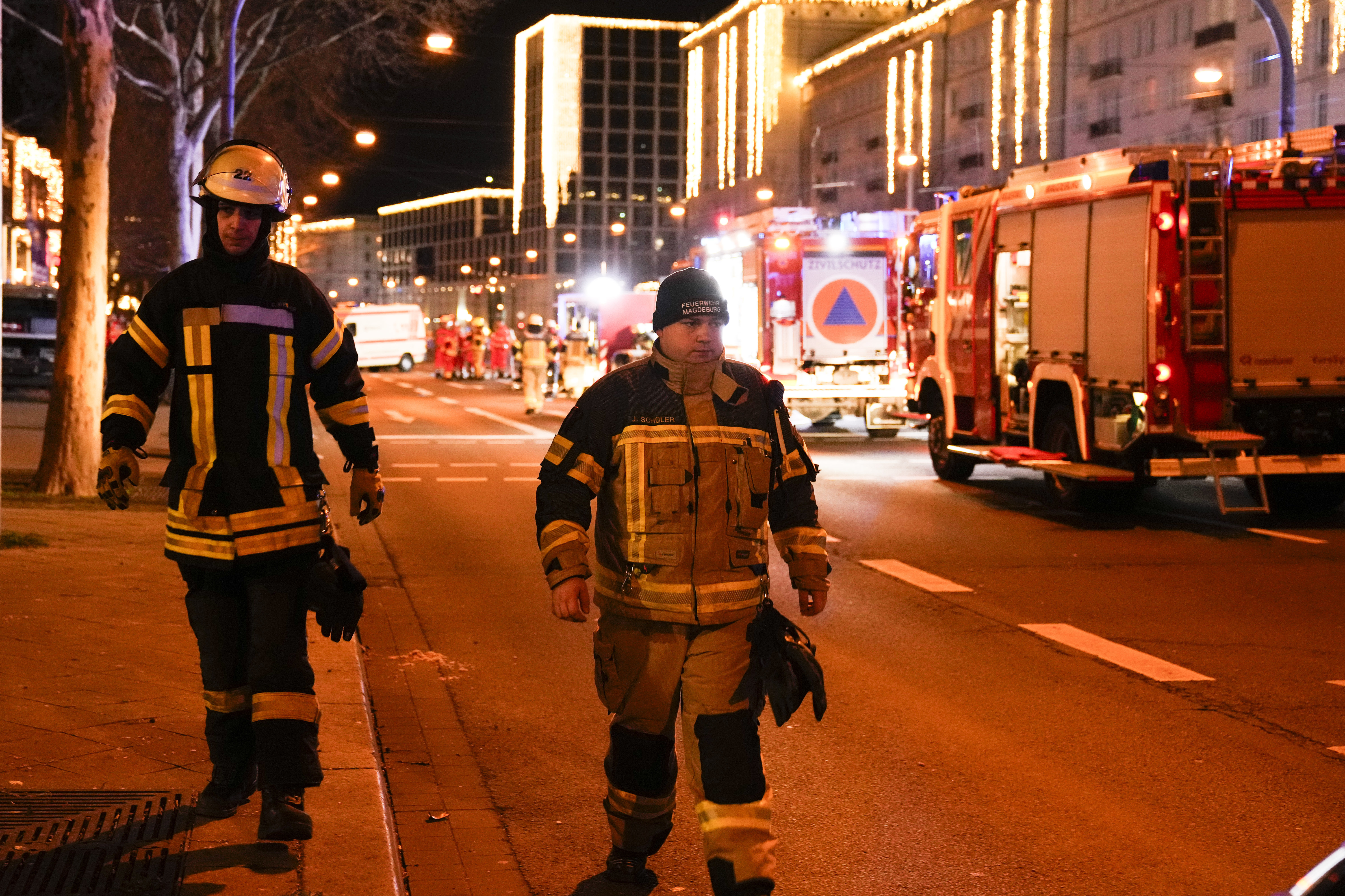 Two firefighters walk through a cordoned-off area near a Christmas Market, after a car drove into a crowd in Magdeburg, Germany, Saturday.
