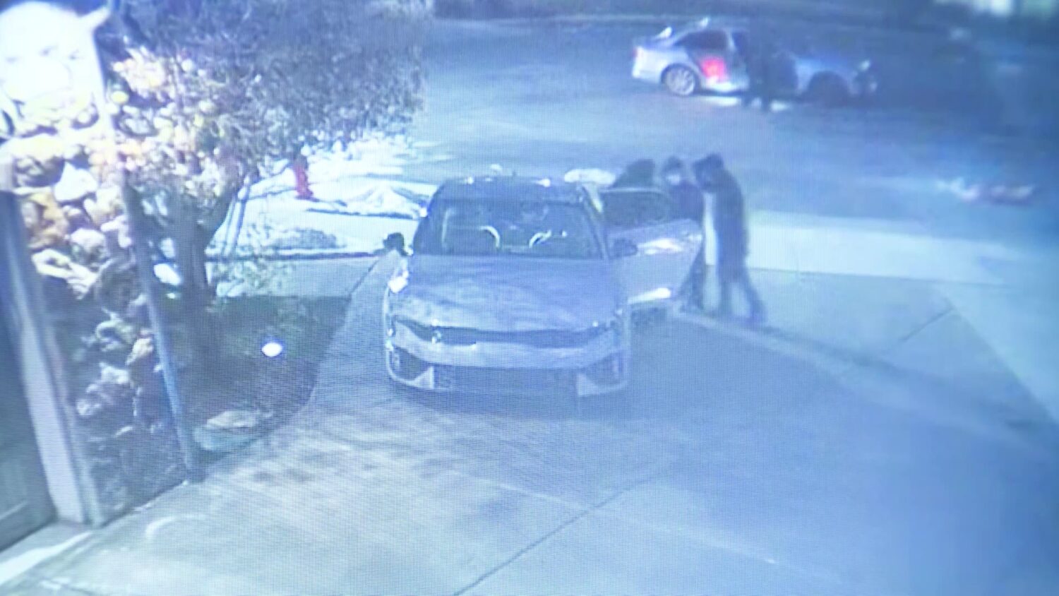 Surveillance footage from a house shows several of the armed suspects searching inside one of the cars Friday.