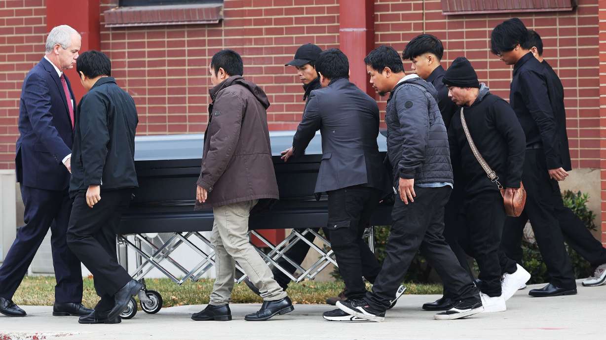 A casket is rolled out after funeral services for West Valley residents Bu Meh, 38, her daughters Kristina Ree, 8, and Nyay Meh, 2, and son Boe Reh, 11, at a chapel of The Church of Jesus Christ of Latter-day Saints in Salt Lake City on Saturday.