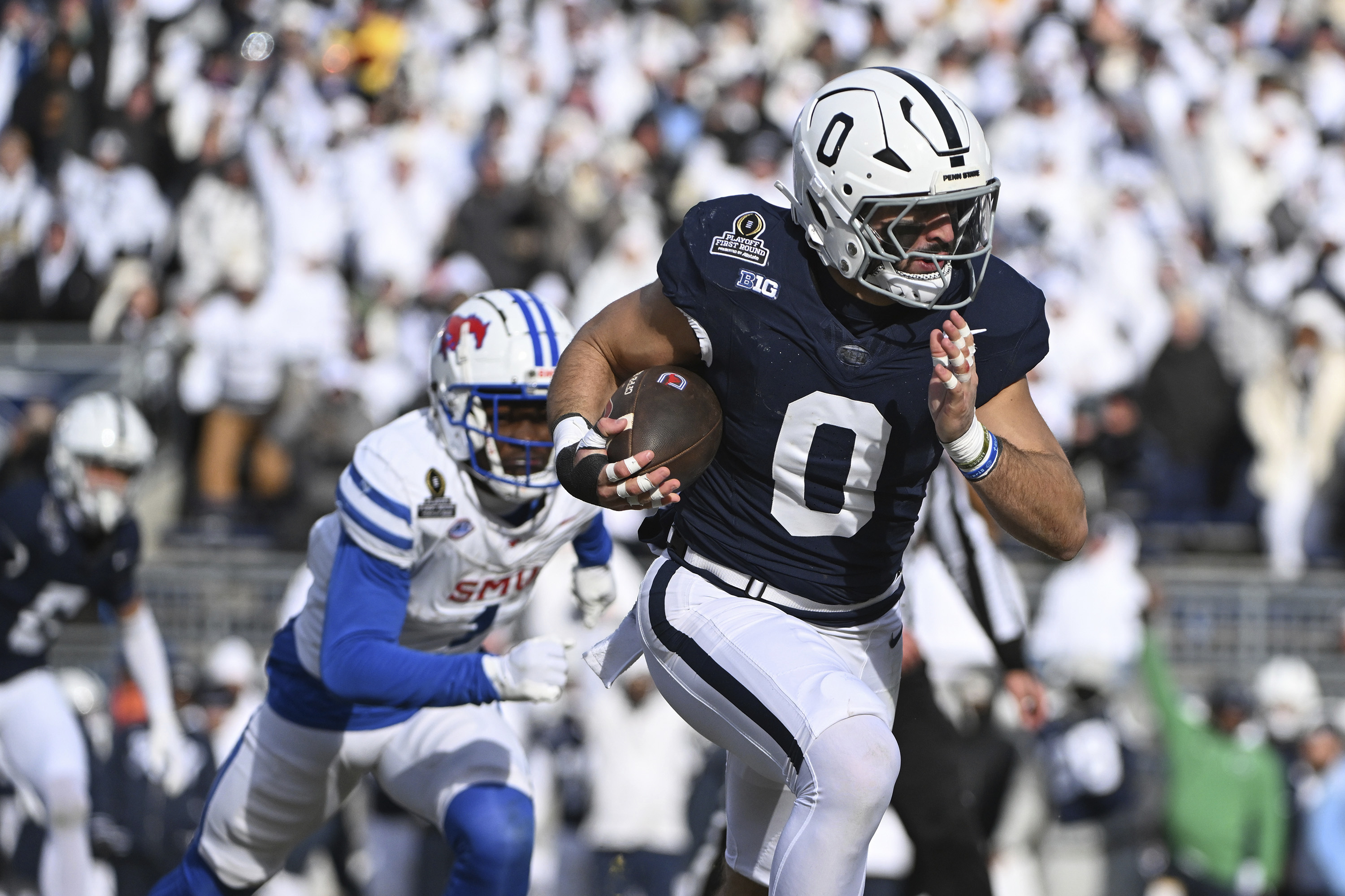 Penn State linebacker Dominic DeLuca returns an interception for a touchdown while being chased by SMU running back Brashard Smith during the first half in the first round of the NCAA College Football Playoff, Saturday, Dec. 21, 2024, in State College, Pa.