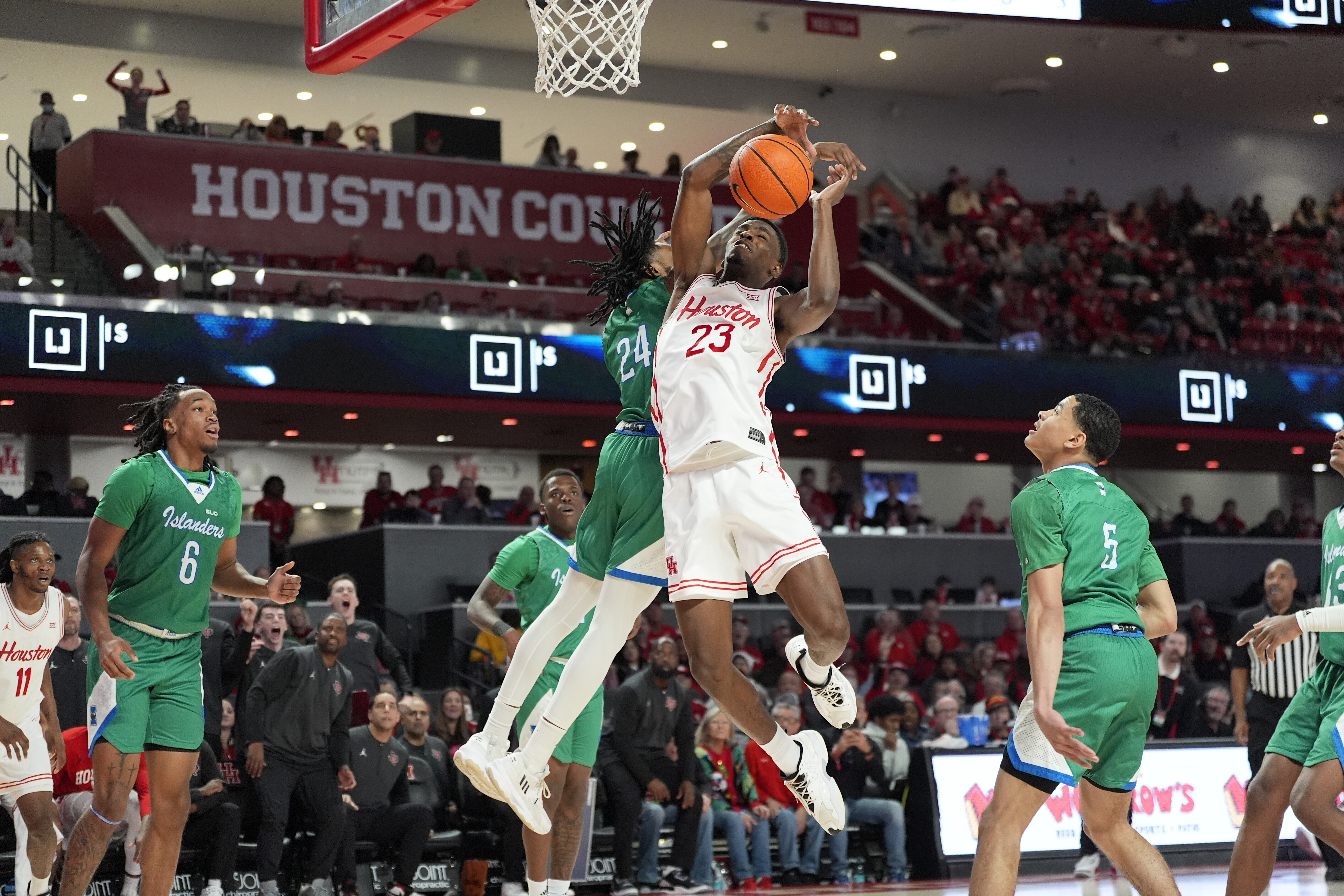 Houston's Terrance Arceneaux (23) has his shot blocked by Texas A&M-Corpus Christi's Aaron Potter (24) during the second half of an NCAA college basketball game Saturday, Dec. 21, 2024, in Houston. 