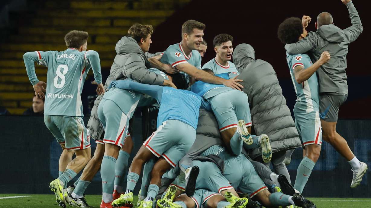 Atletico Madrid players celebrate their victory goal during the Spanish La Liga soccer match between Barcelona and Atletico Madrid at the Lluis Companys Olympic Stadium in Barcelona, Spain, Saturday, Dec. 21, 2024.