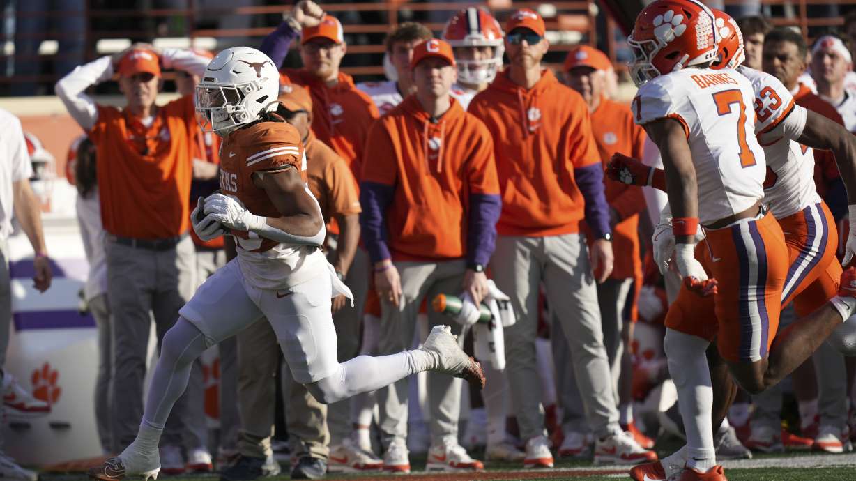Texas running back Jaydon Blue, left, runs from Clemson safety Khalil Barnes (7) during a 38-yard touchdown run in the first half in the first round of the College Football Playoff, Saturday, Dec. 21, 2024, in Austin, Texas.