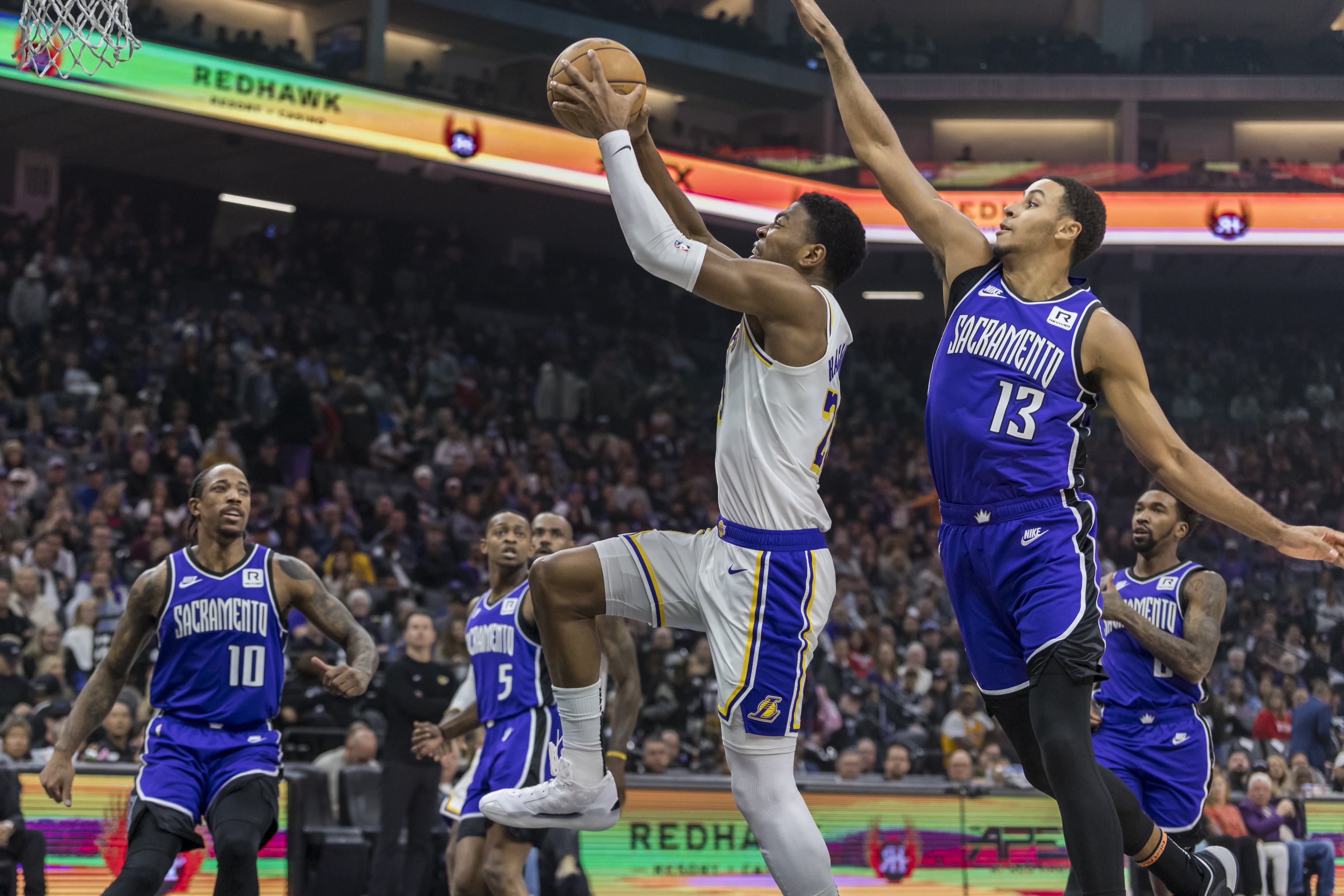 Los Angeles Lakers forward Rui Hachimura dunks with Sacramento Kings forward Keegan Murray (13) on defense during the first half of an NBA basketball game, Saturday, Dec. 21, 2024, in Sacramento, Calif.