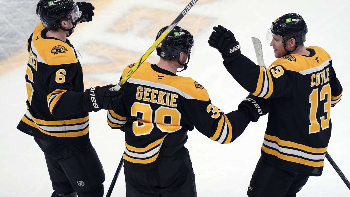 Boston Bruins' Morgan Geekie (39) celebrates his go-ahead goal with teammates Mason Lohrei (6) and Charlie Coyle (13) during the third period of an NHL hockey game against the Buffalo Sabres, Saturday, Dec. 21, 2024, in Boston.