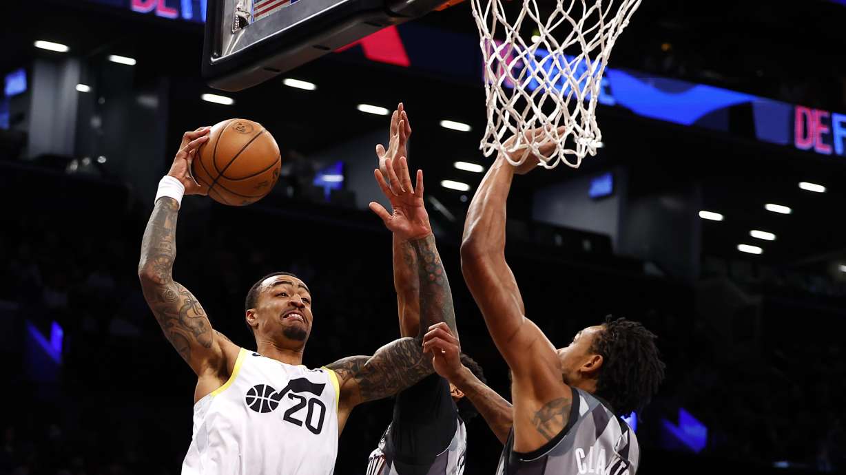 Utah Jazz forward John Collins (20) drives to the basket against Brooklyn Nets center Nic Claxton during the first half of an NBA basketball game, Saturday, Dec. 21, 2024, in New York.