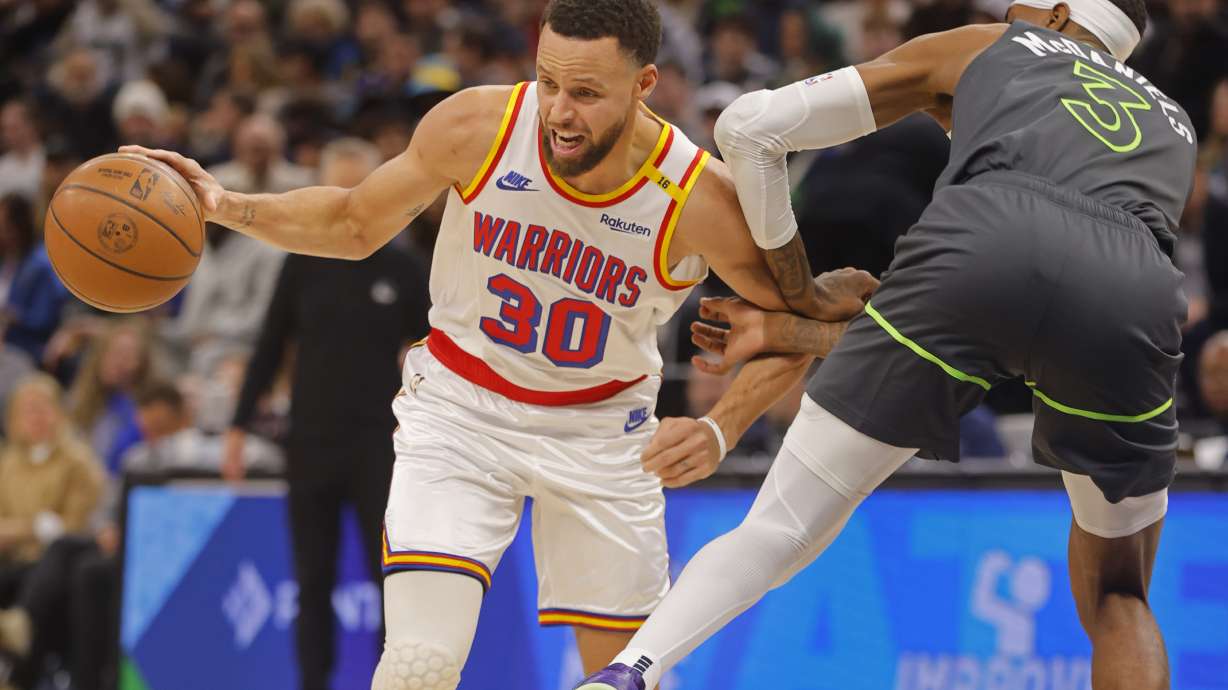 Golden State Warriors guard Stephen Curry (30) works around Minnesota Timberwolves forward Jaden McDaniels (3) in the first quarter of an NBA basketball game Saturday, Dec. 21, 2024, in Minneapolis.