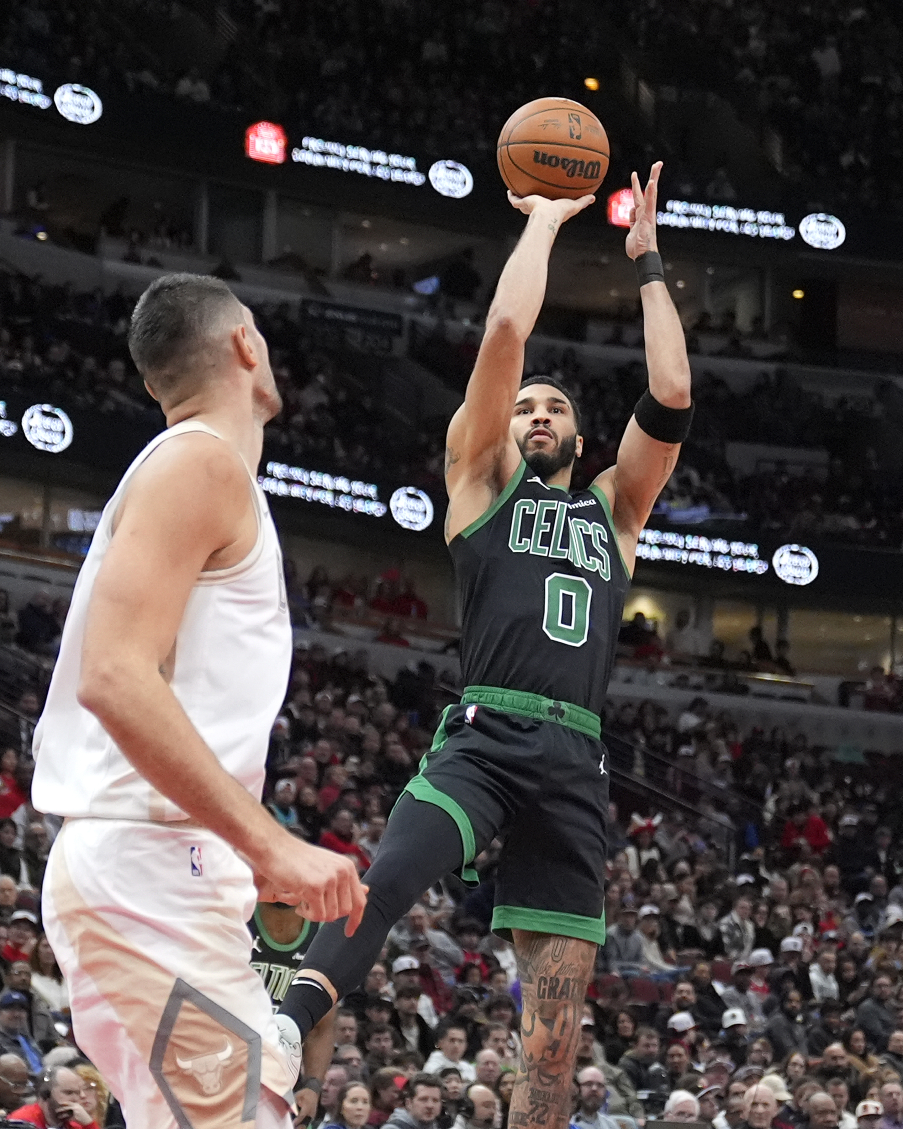 Boston Celtics' Jayson Tatum shoots as Chicago Bulls' Nikola Vucevic watches during the first half of an NBA basketball game Saturday, Dec. 21, 2024, in Chicago.