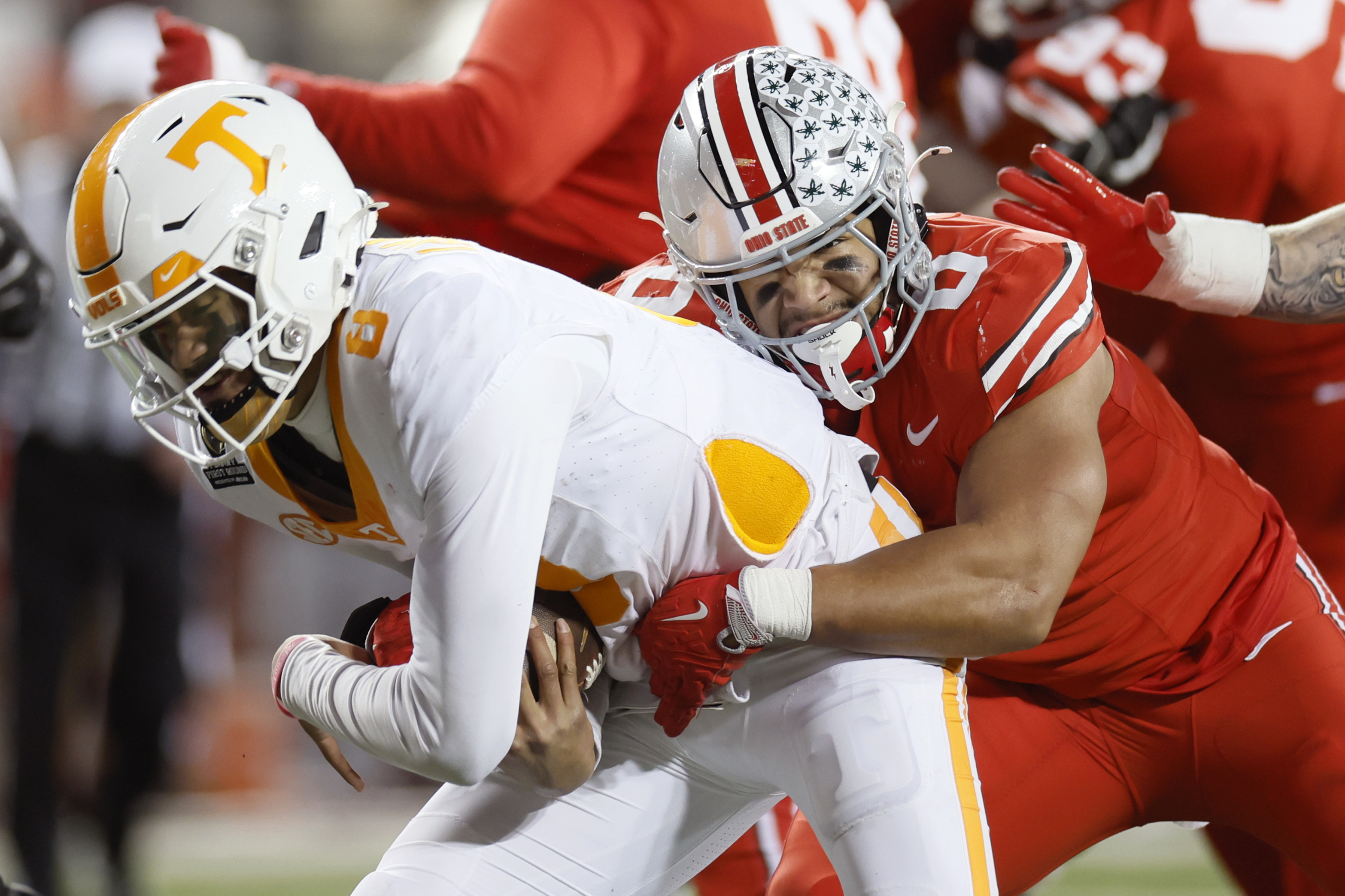Ohio State linebacker Cody Simon, right, tackles Tennessee quarterback Nico Iamaleava, left, during the first half in the first round of the College Football Playoff, Saturday, Dec. 21, 2024, in Columbus, Ohio.