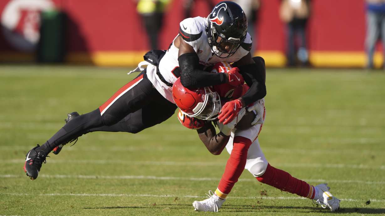 Kansas City Chiefs wide receiver Hollywood Brown is tackled by Houston Texans safety Eric Murray, left, during the first half of an NFL football game Saturday, Dec. 21, 2024, in Kansas City, Mo.