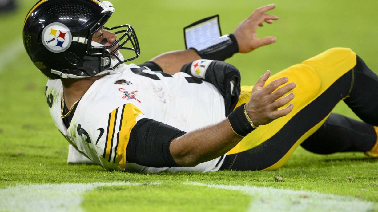Pittsburgh Steelers quarterback Russell Wilson looks on from the turf as Baltimore Ravens cornerback Marlon Humphrey returns an interception for a touchdown during the second half of an NFL football game, Saturday, Dec. 21, 2024, in Baltimore.