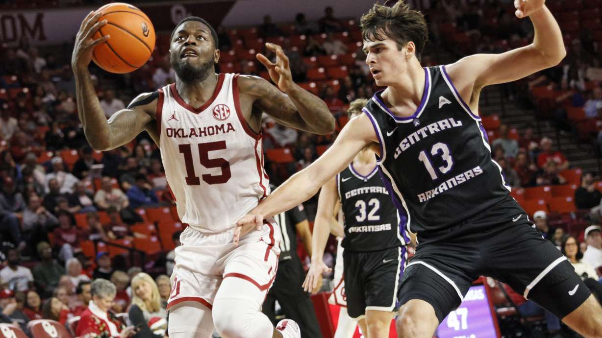 Oklahoma guard Duke Miles (15) drives next to Central Arkansas guard Ben Fox (13) during the second half of an NCAA college basketball game, Sunday, Dec. 22, 2024, in Norman, Okla.