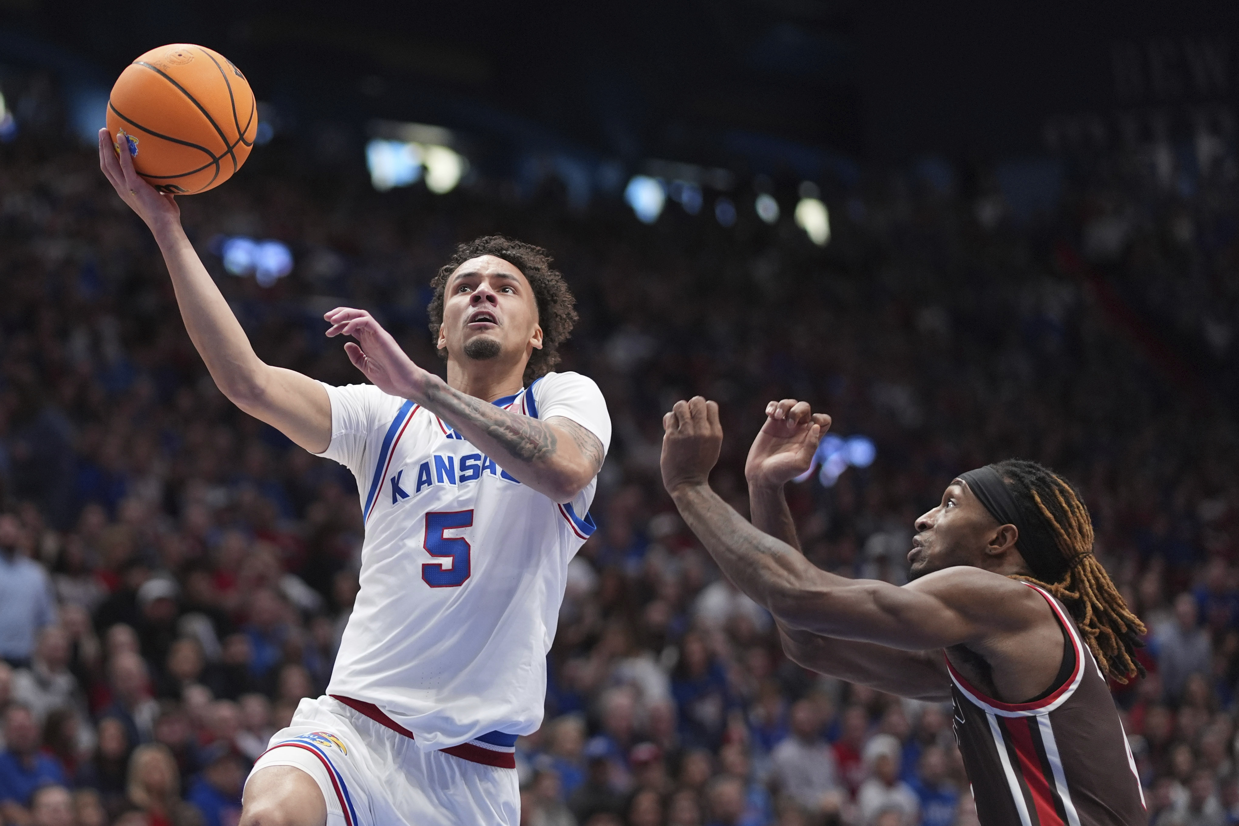 Kansas guard Zeke Mayo (5) gets past Brown guard Lyndel Erold (4) to put up a shot during the first half of an NCAA college basketball game, Sunday, Dec. 22, 2024, in Lawrence, Kan. 