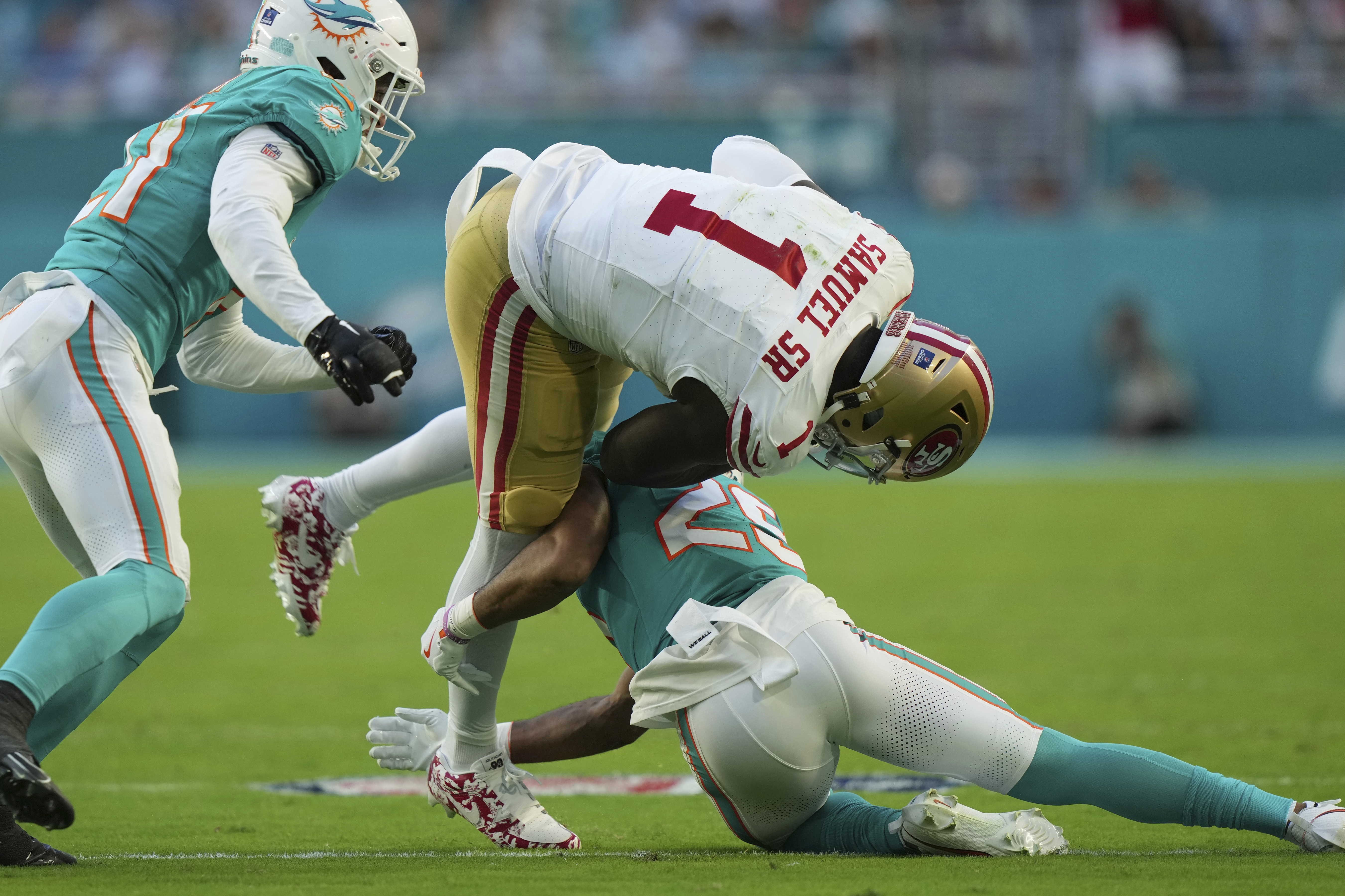 San Francisco 49ers wide receiver Deebo Samuel Sr. (1) is tackled by Miami Dolphins running back Jaylen Wright (25) during the first half of an NFL football game, Sunday, Dec. 22, 2024, in Miami Gardens, Fla.