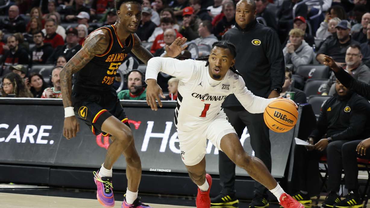 Cincinnati's Day Day Thomas, right, dribbles past Grambling State's Ernest Ross during the first half of an NCAA college basketball game, Sunday, Dec. 22, 2024, in Cincinnati.