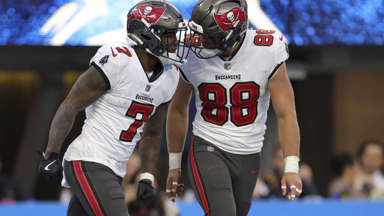 Tampa Bay Buccaneers running back Bucky Irving (7) celebrates after a long run with tight end Cade Otton (88) during the second half of an NFL football game against the Los Angeles Chargers, Sunday, Dec. 15, 2024, in Inglewood, Calif.
