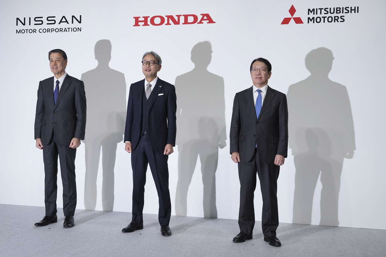 Nissan Chief Executive Makoto Uchida, left, Honda Chief Executive Toshihiro Mibe, center, and Takao Kato, CEO of Mitsubishi Motors, right, pose for photographers during a joint news conference in Tokyo, Japan, Monday.