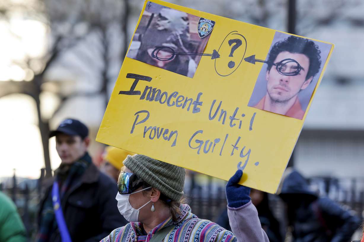 A demonstrator holds up a sign while waiting for the arrival of Luigi Mangione for his arraignment at Manhattan Criminal Court, Monday, in New York.