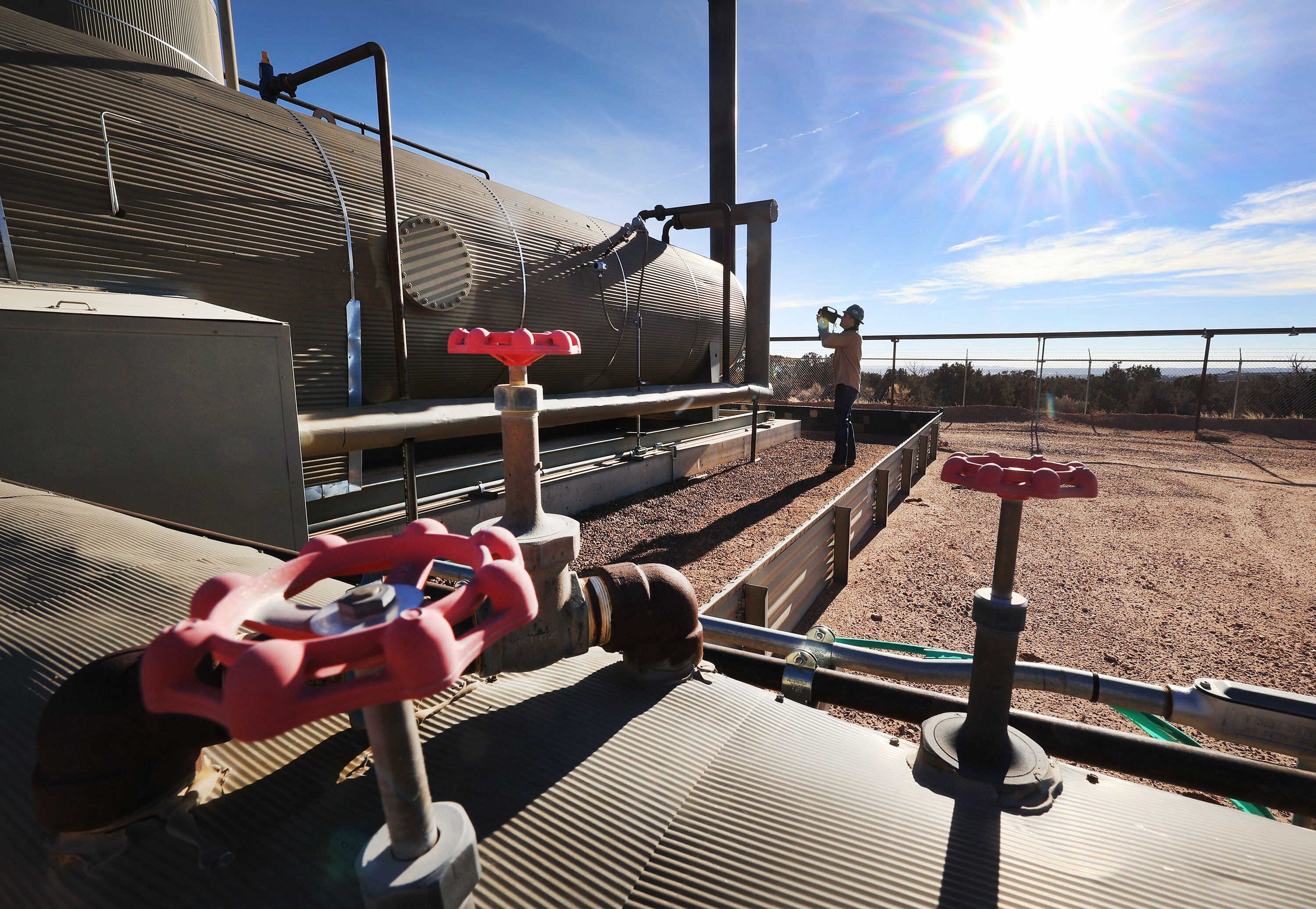 Stephen Foulger, an environmental scientist with the Utah Department of Environmental Quality, inspects an oil pump site near Roosevelt on Dec. 1, 2021.