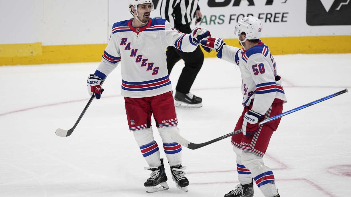 New York Rangers' Chris Kreider (20) and Will Cuylle (50) celebrate an empty-net goal scored by Kreider in the third period of an NHL hockey game against the Dallas Stars in Dallas, Friday, Dec. 20, 2024.