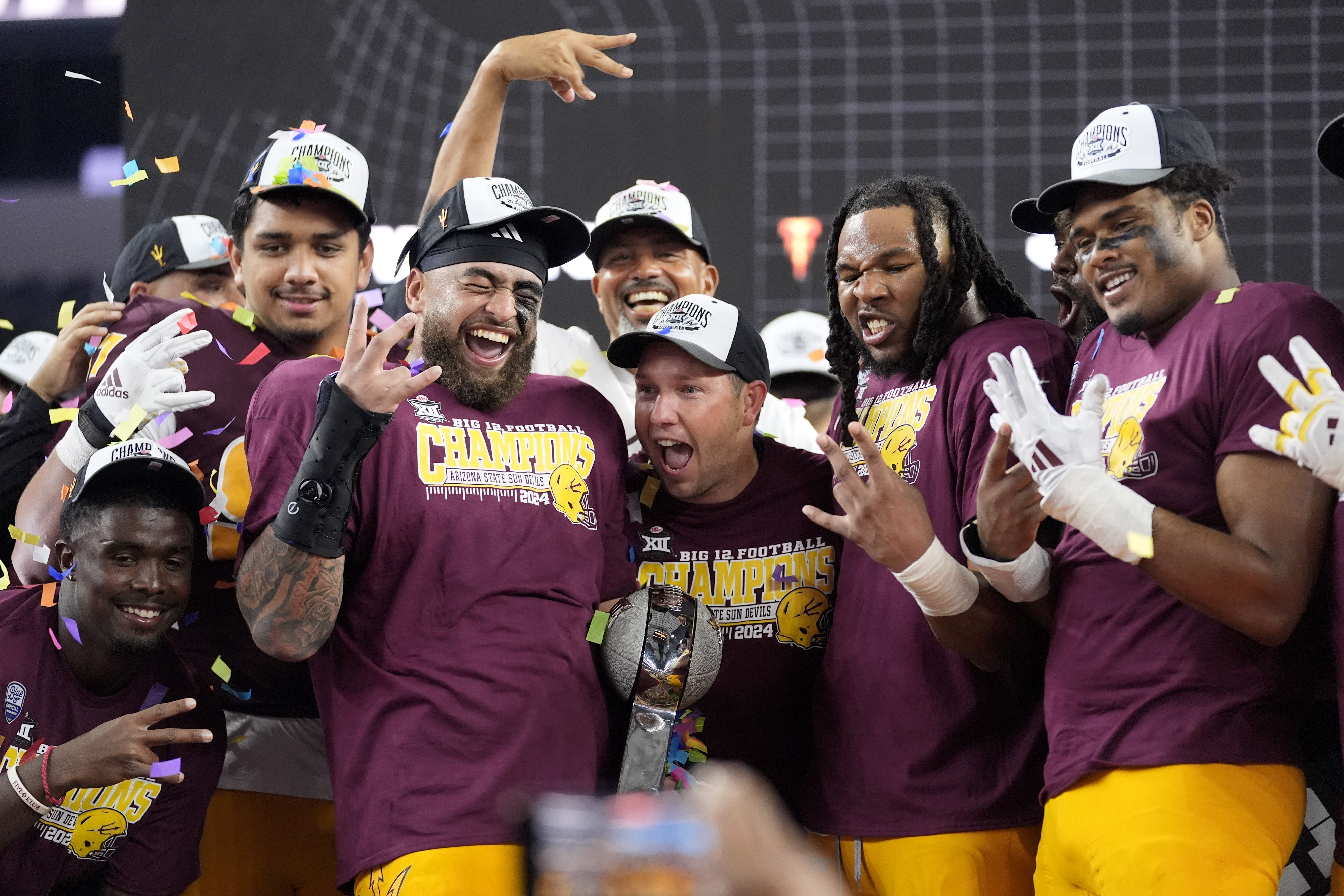 Ariona State head coach Kenny Dillingham, center, celebrates with his team after their win in the Big 12 Conference championship NCAA college football game against Iowa State, in Arlington, Texas, Saturday Dec. 7, 2024.