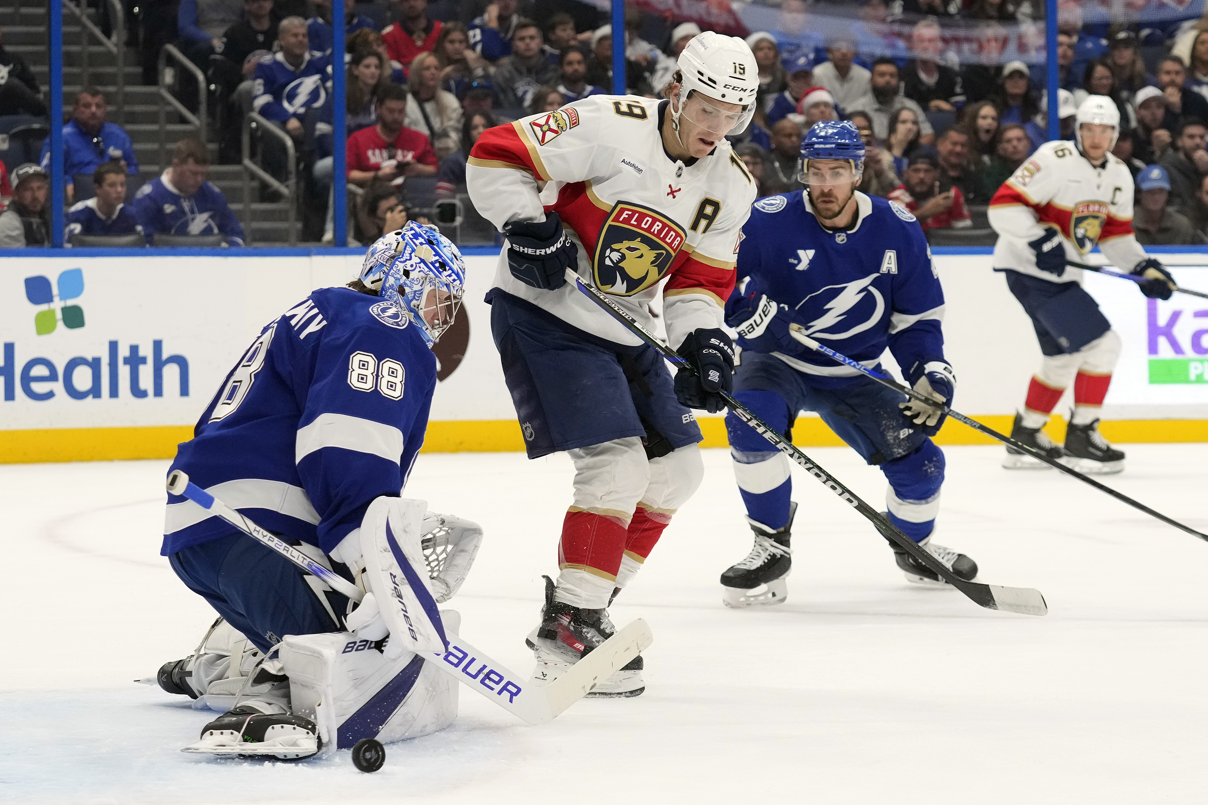 Tampa Bay Lightning goaltender Andrei Vasilevskiy (88) makes a pad-save on a deflection by Florida Panthers left wing Matthew Tkachuk (19) during the first period of an NHL hockey game Sunday, Dec. 22, 2024, in Tampa, Fla.